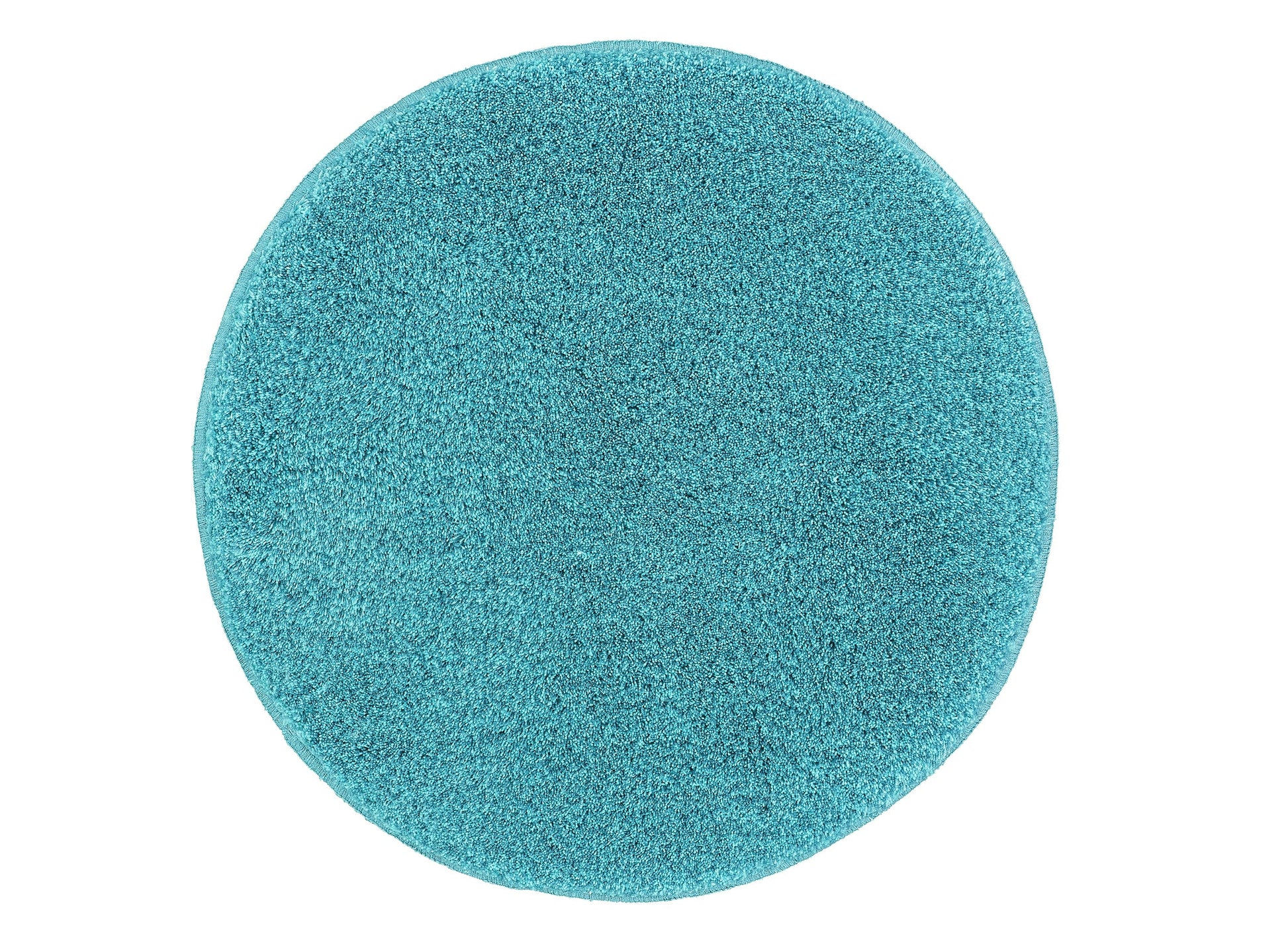Ein runder, hochfloriger Teppich in Türkis liegt vollständig ausgebreitet auf hellem Untergrund.