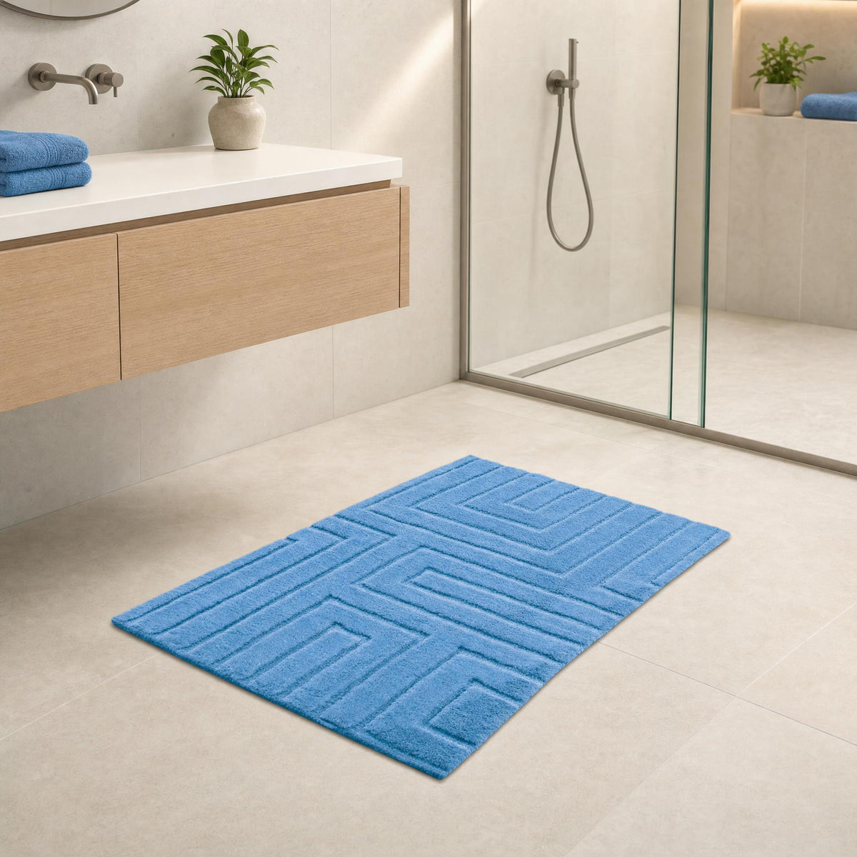 Blauer Badteppich in modernem Bad vor Dusche und hellem Waschtisch.
