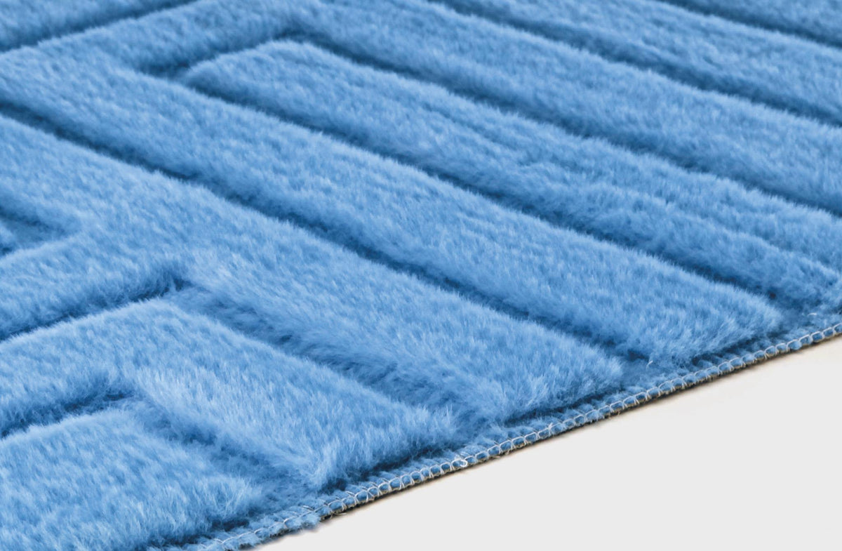 Hellblauer flauschiger Teppich mit gerippter Struktur in Nahaufnahme.