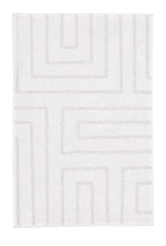 Weißer Badteppich mit geometrischem Linienmuster.