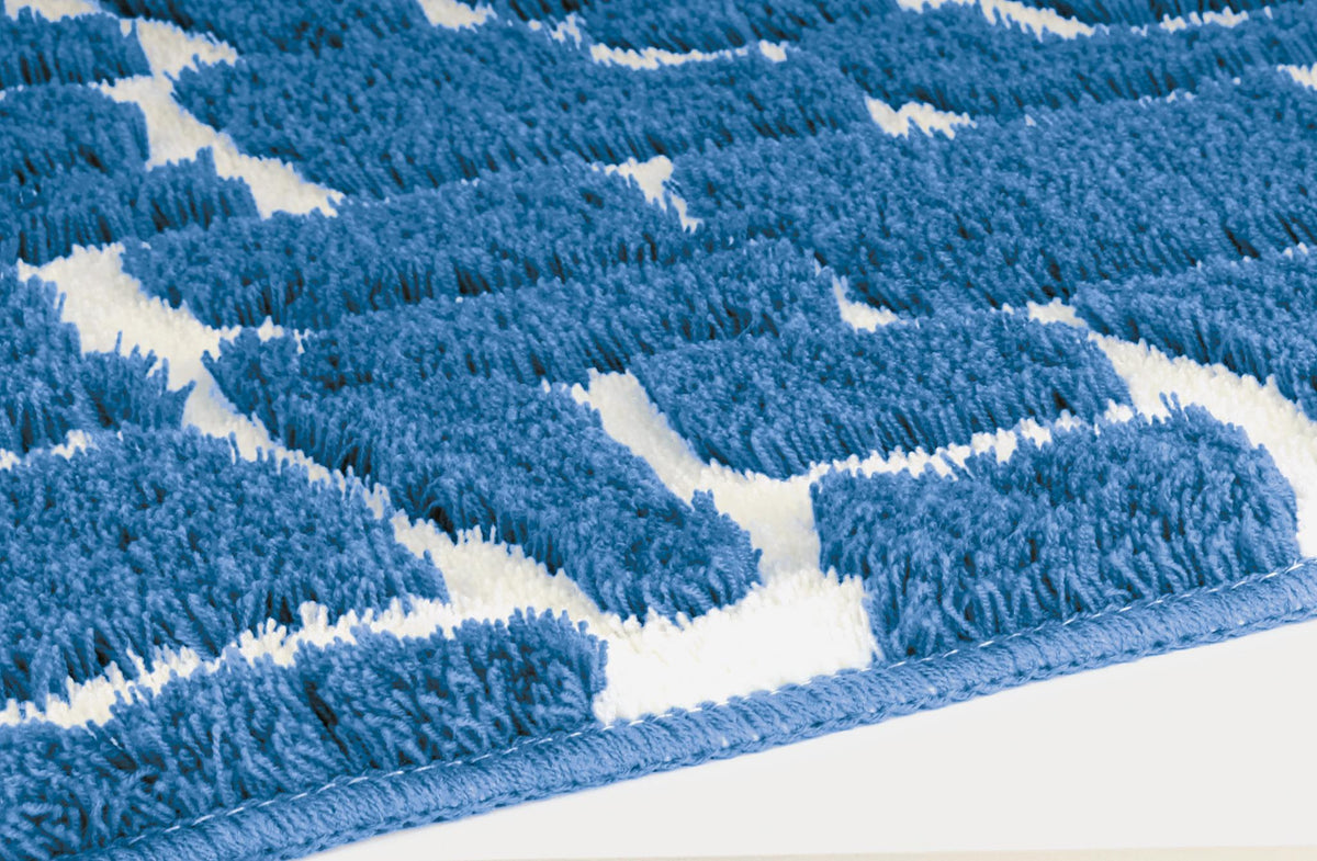 Blau-weißer Badteppich mit Zickzackmuster in Nahaufnahme.