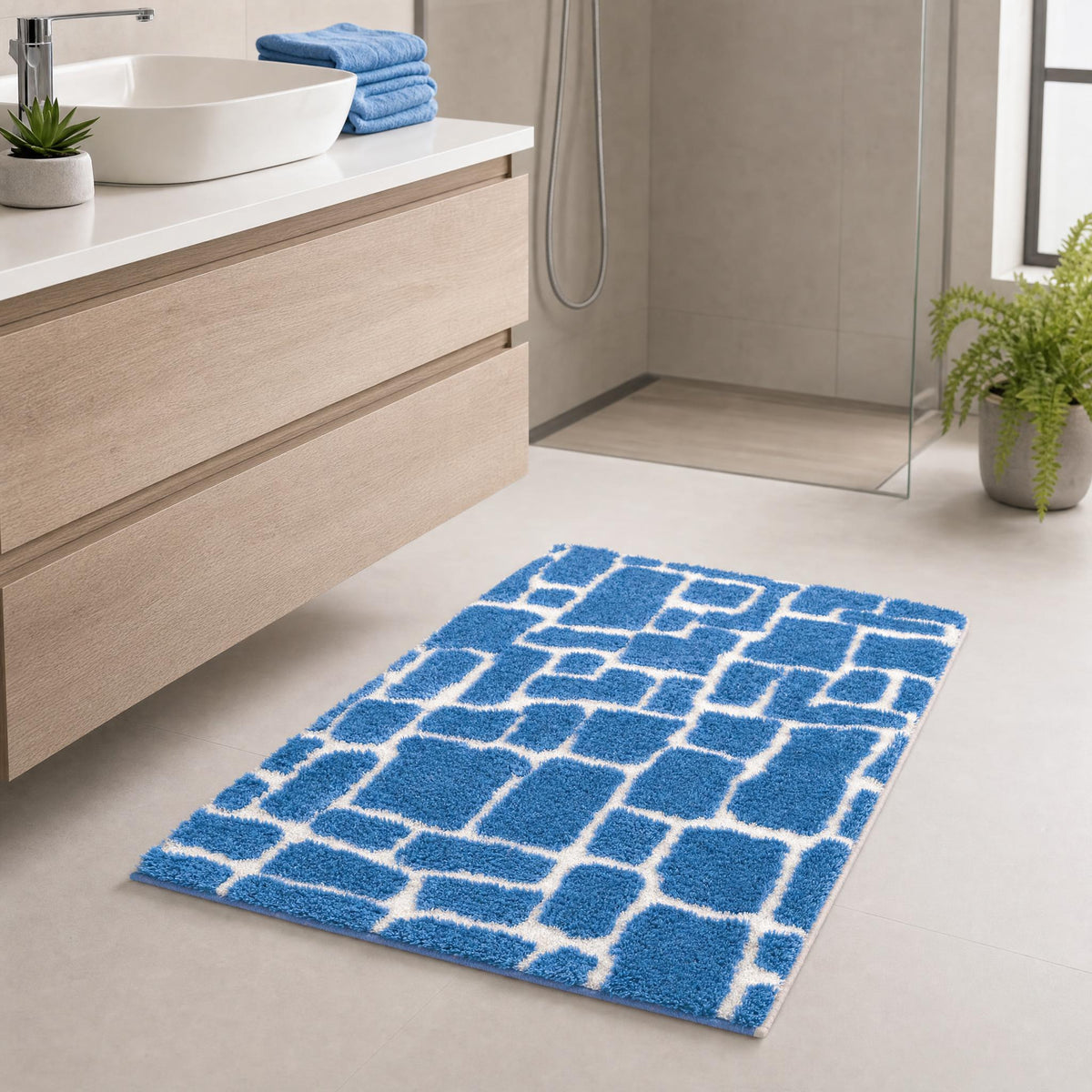 Blauer Badteppich mit weißem Muster in modernem Badezimmer.
