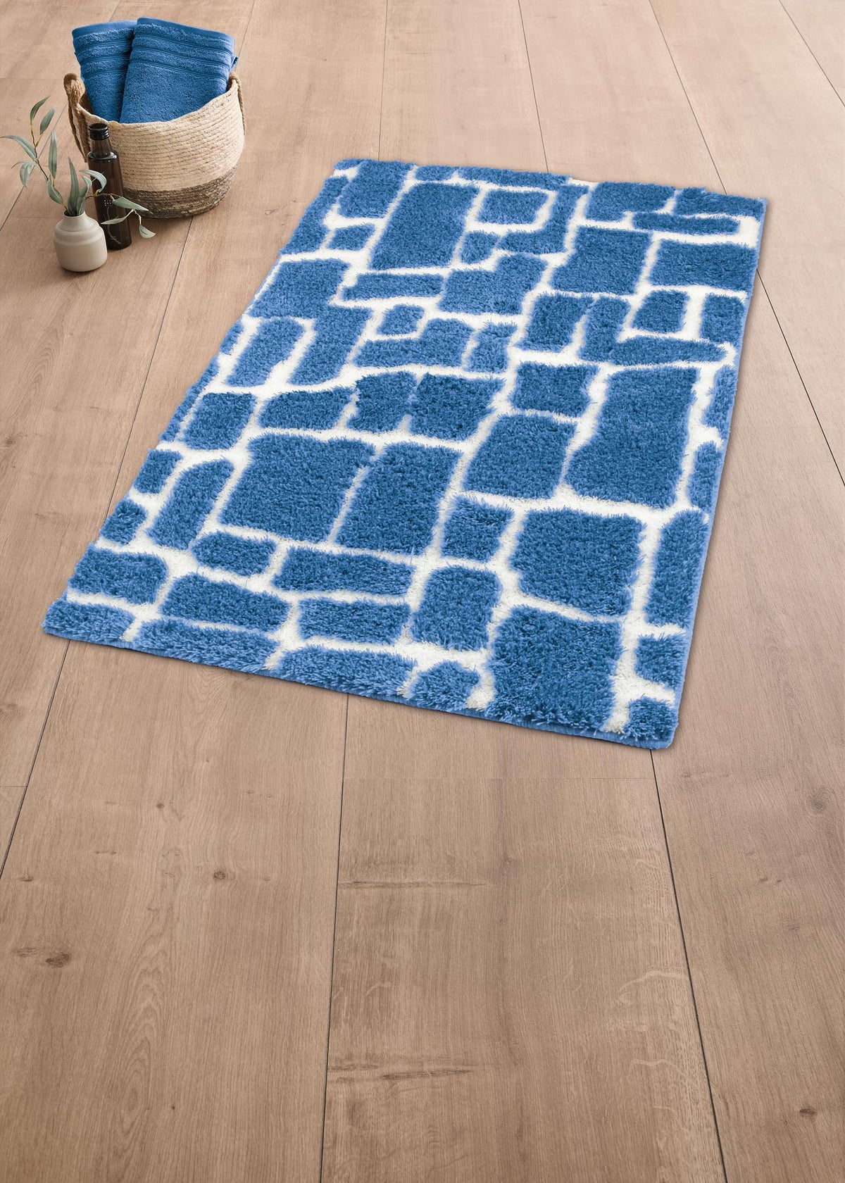 Blauer Badteppich mit weißem Muster auf Holzoptikboden.