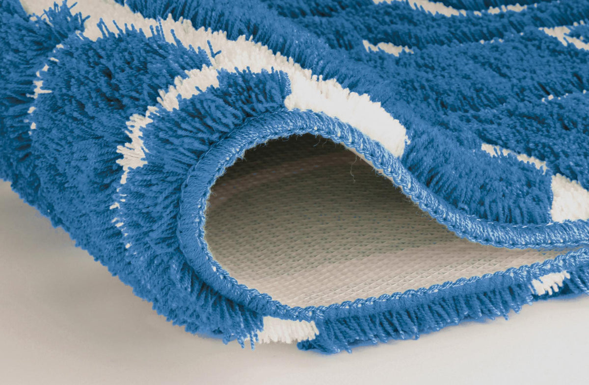 Blau-weißer Badteppich in Nahaufnahme, an einer Ecke umgeschlagen.