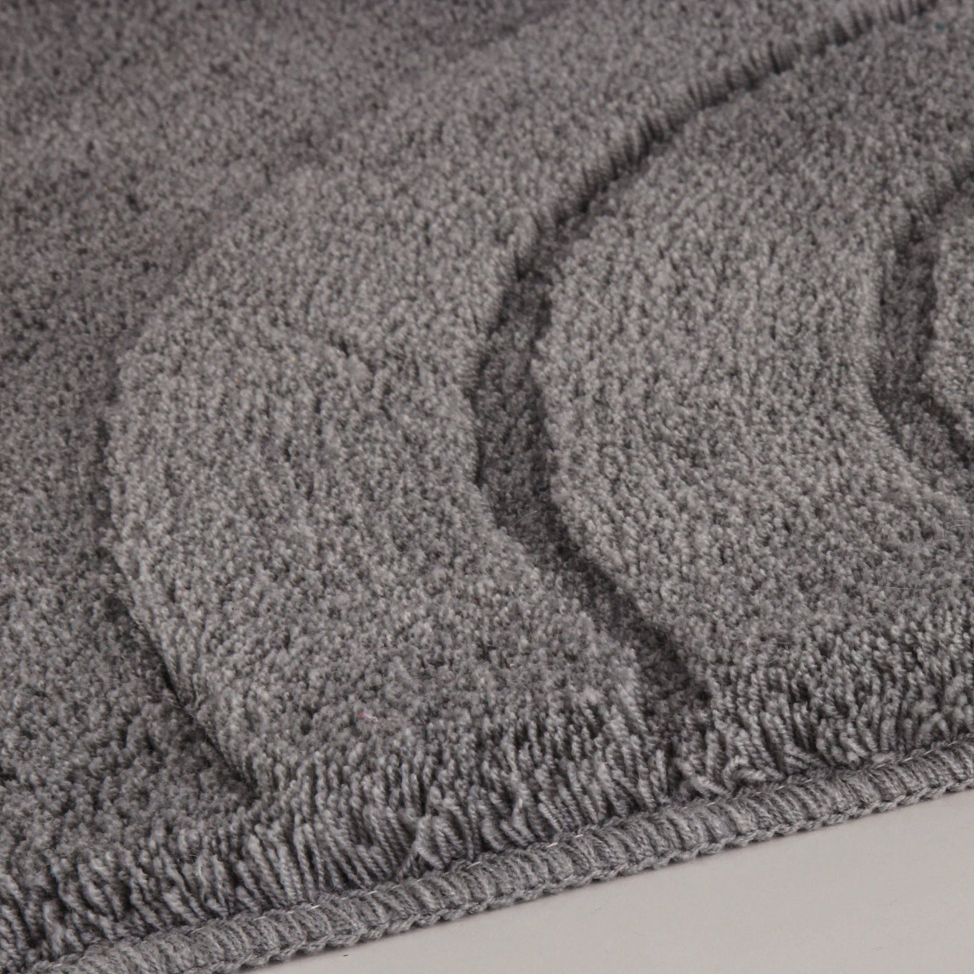 Nahaufnahme des Badteppichs SATURN in Anthrazit, Größe 55 x 65 cm, mit strukturierter Oberfläche.