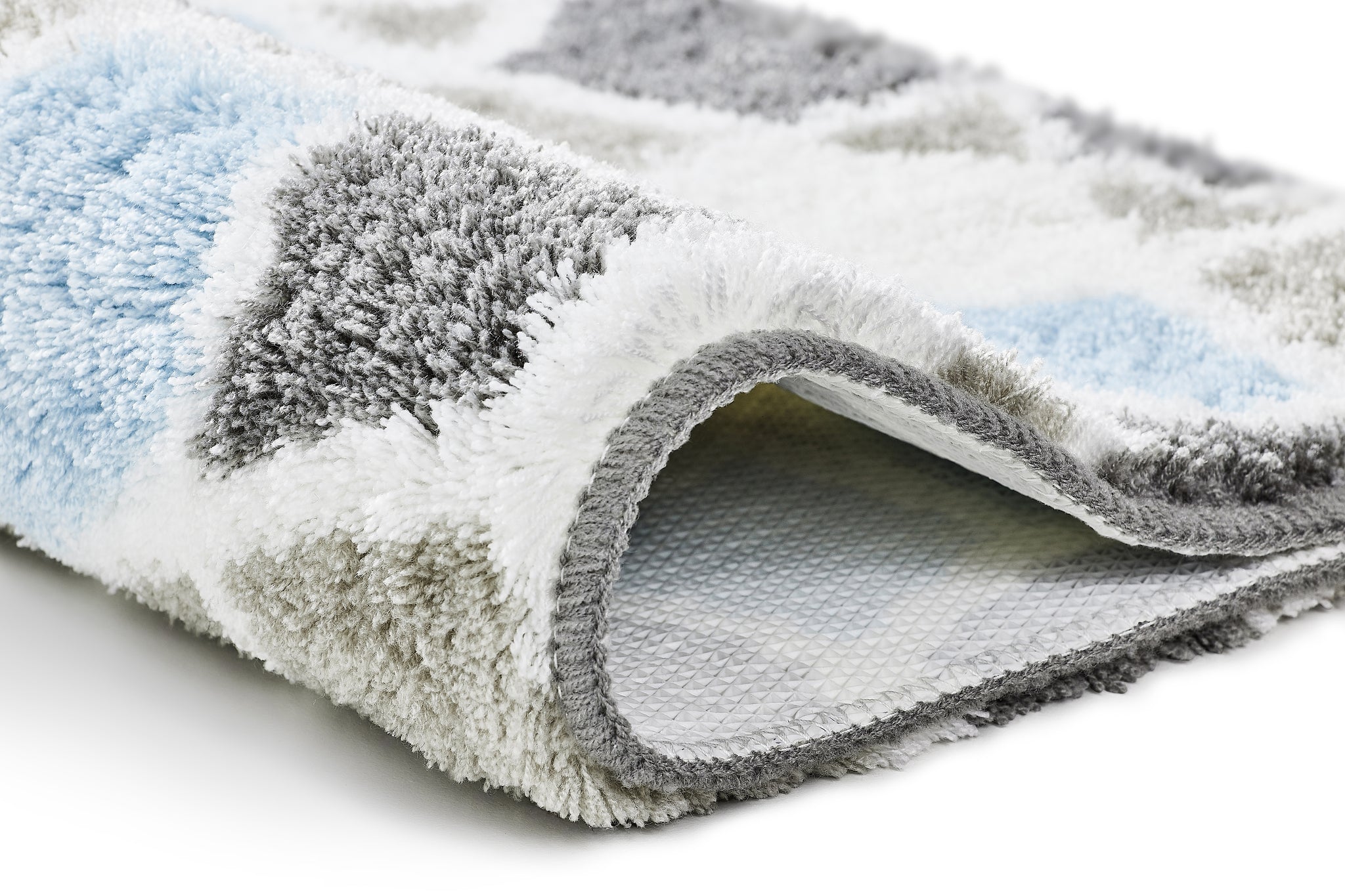 Badteppich SINTRA Opal 55 x 65 cm in Nahaufnahme mit blau-grau-weißem, hochflorigem Muster und rutschhemmender Unterseite.