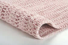 Rosa Badematte mit Waffelstruktur, teilweise gerollt in Nahaufnahme