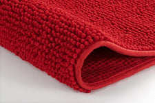 Rote Badematte mit weicher, dichter Noppenstruktur in Nahaufnahme