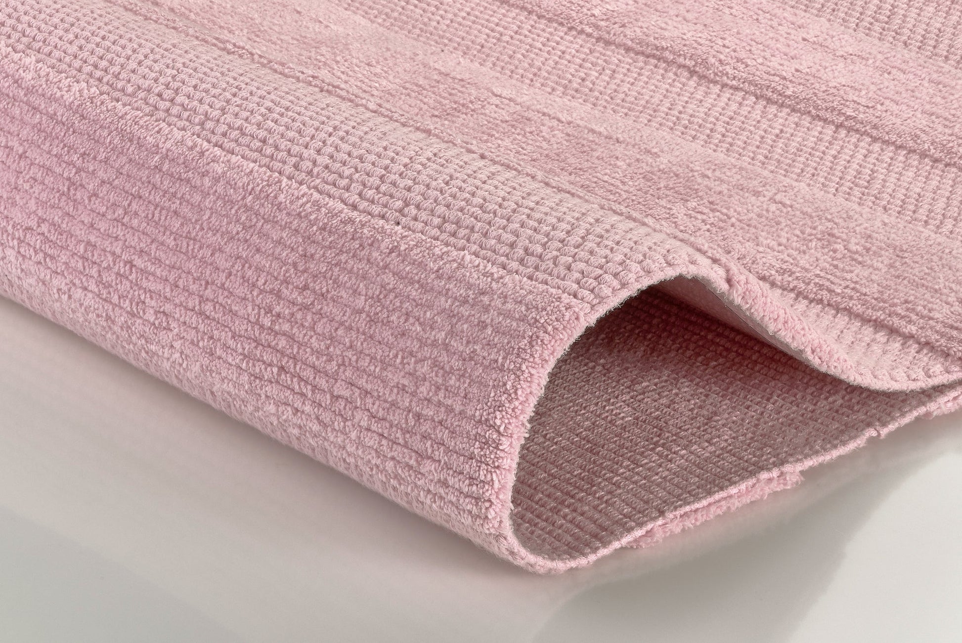 Gefaltete rosa Badematte mit strukturierter Oberfläche aus Frottee