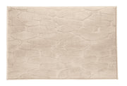 Badteppich TONDO seidenfarben 70 x 120 cm liegt rechteckig mit Steinmuster auf hellem Untergrund.