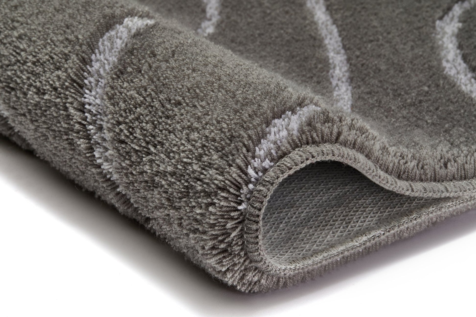 Detailansicht Badteppich TRAM Anthrazit 70 x 120 cm mit weichem Flor und sichtbar umgeschlagener Ecke.