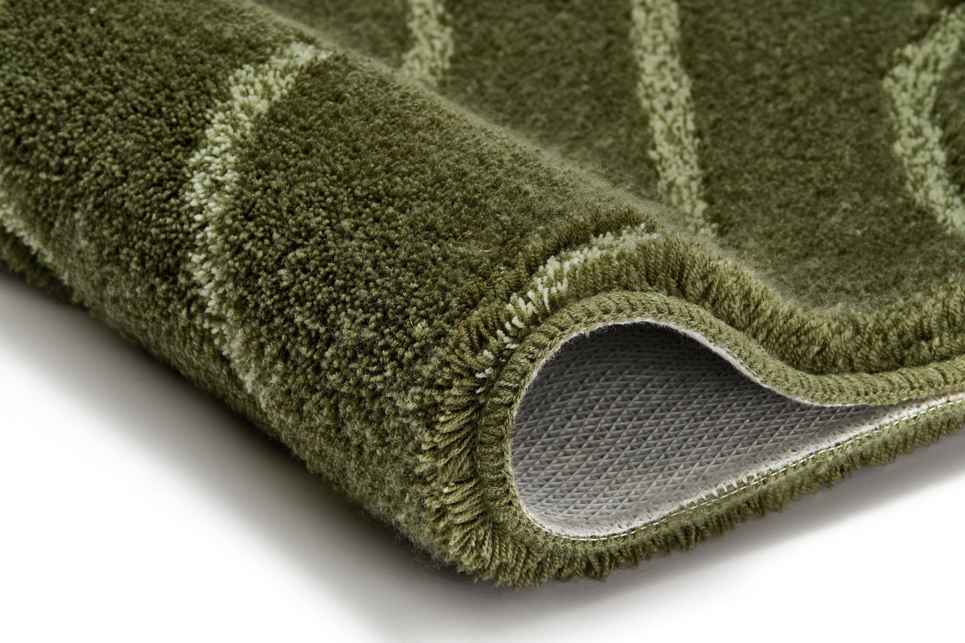 Nahaufnahme des grünen Badteppichs TRAM Forest 80 x 140 cm mit sichtbarer Rückseite.