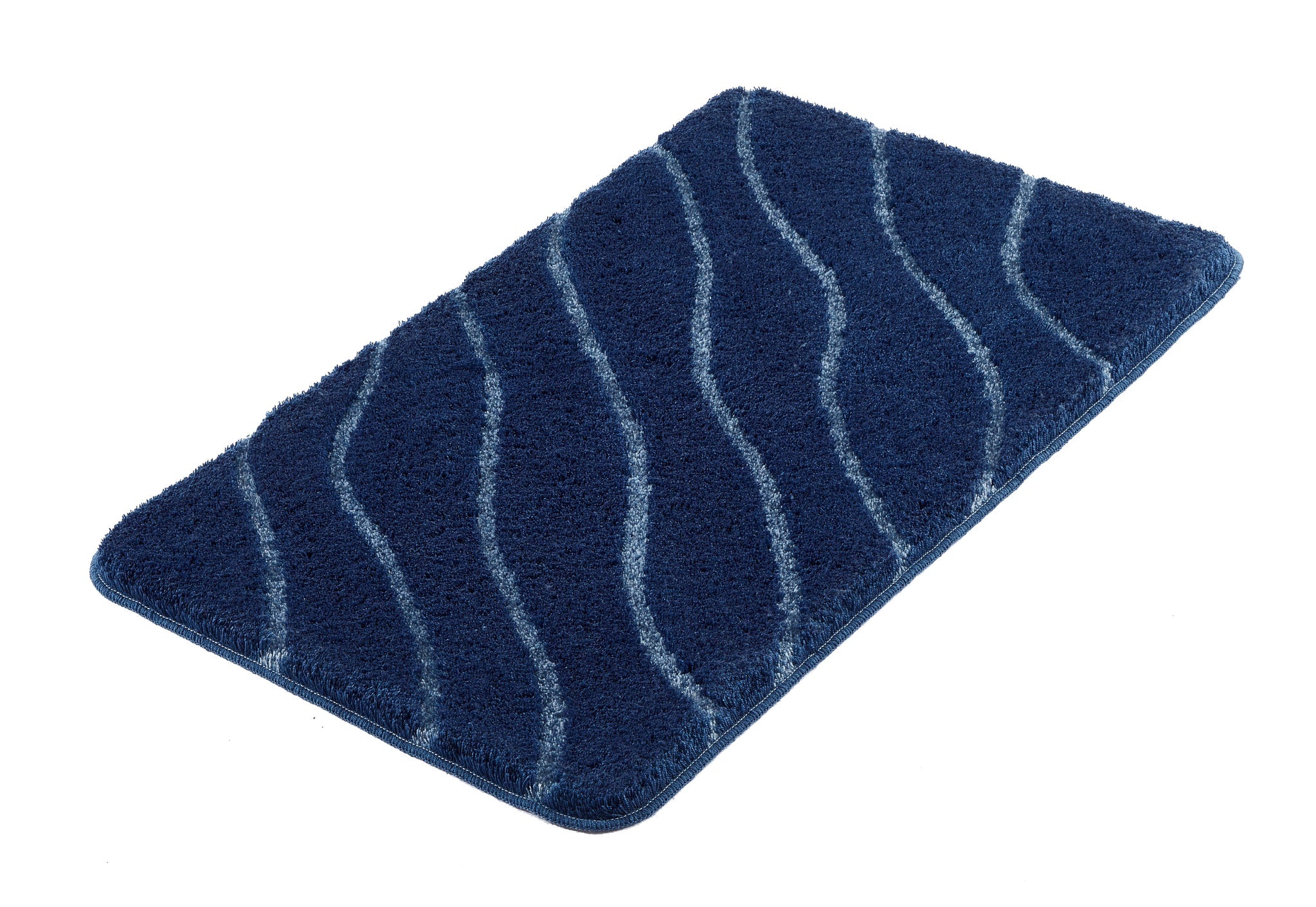 Badteppich TRAM Mare 80 x 140 cm liegt in Blau mit wellenförmigem Muster auf weißem Hintergrund.