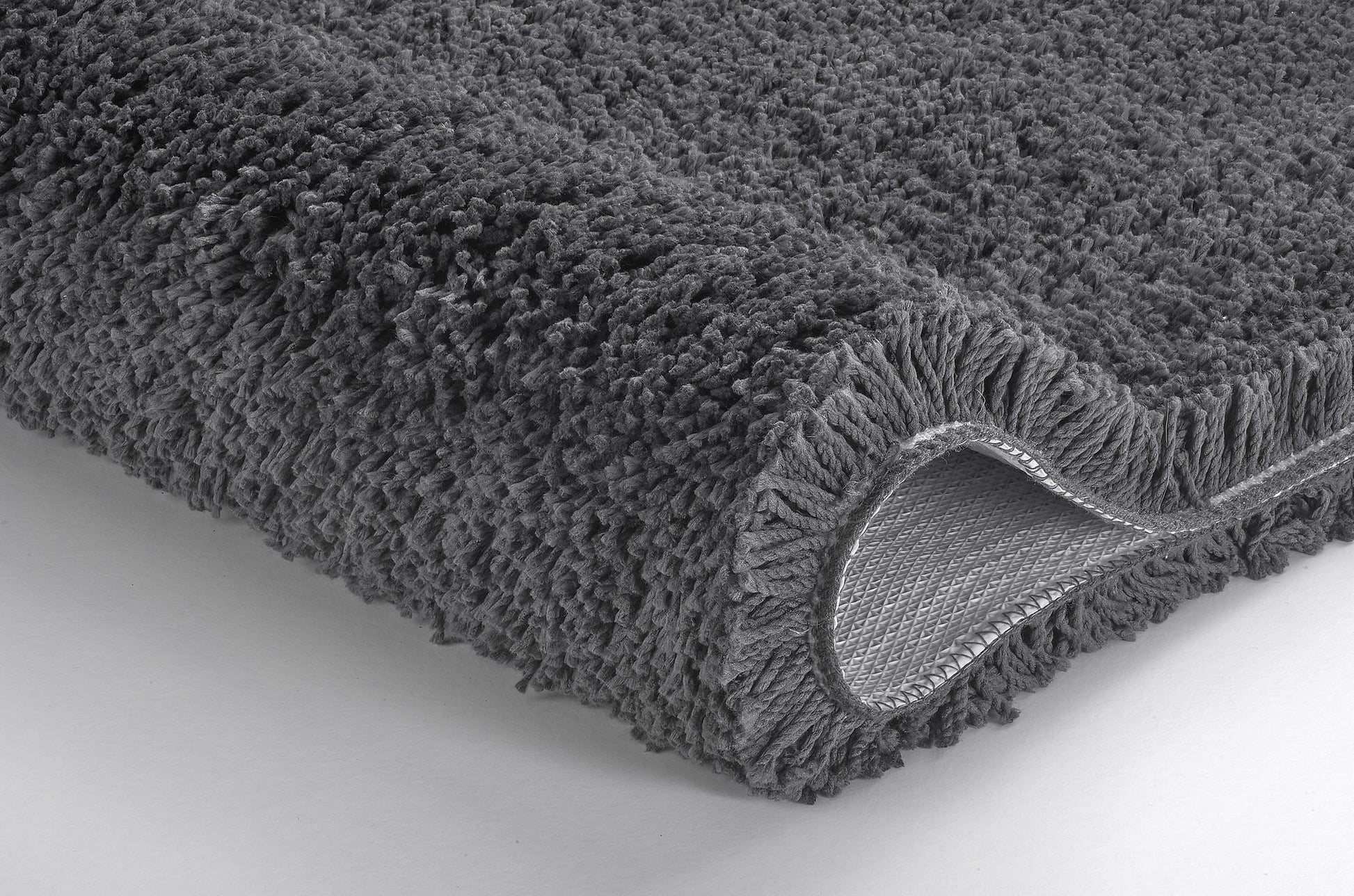 Grauer, hochfloriger Badteppich, Ecke leicht nach oben umgeschlagen