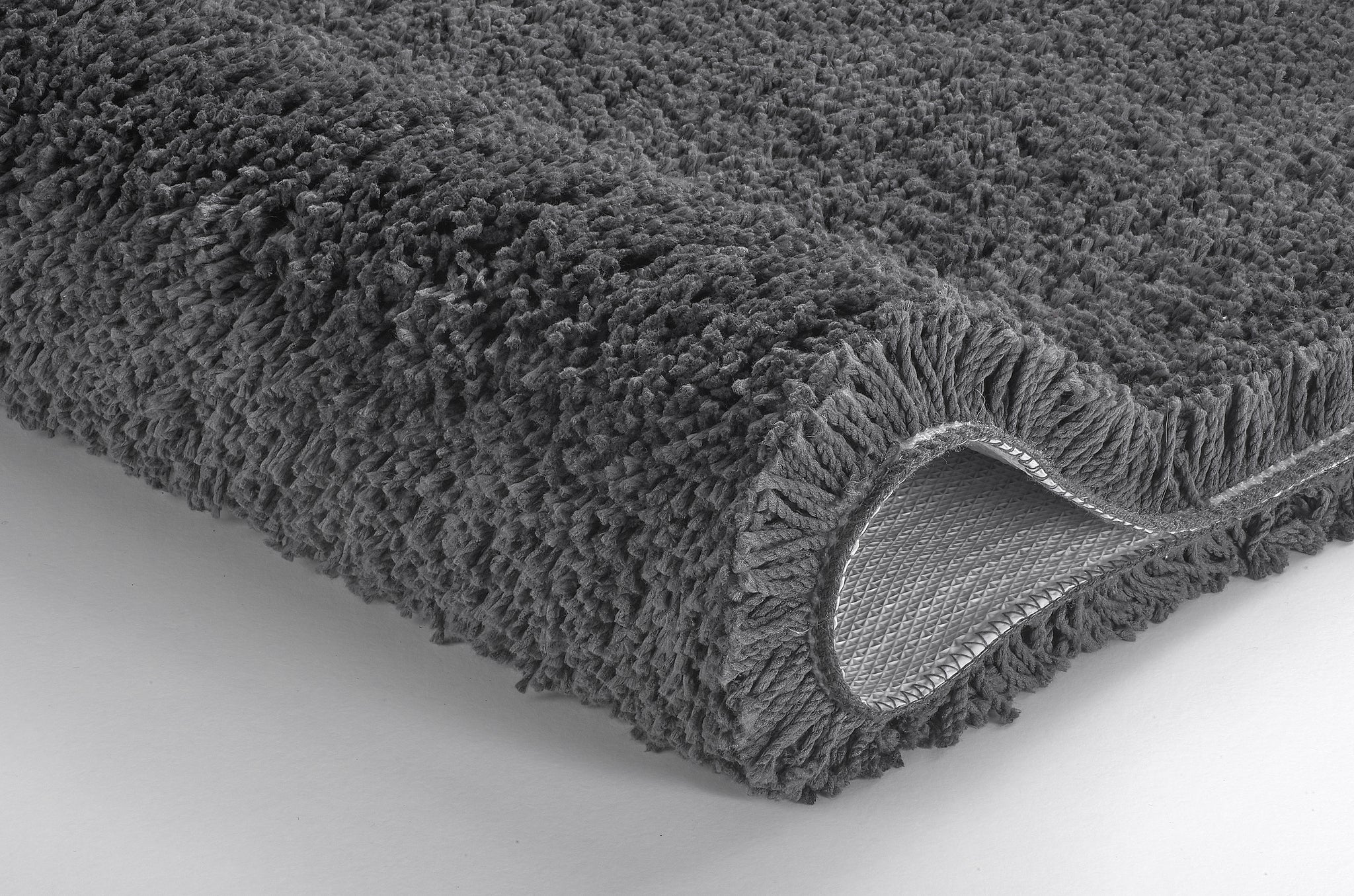 Grauer, hochfloriger Badteppich, Ecke leicht nach oben umgeschlagen