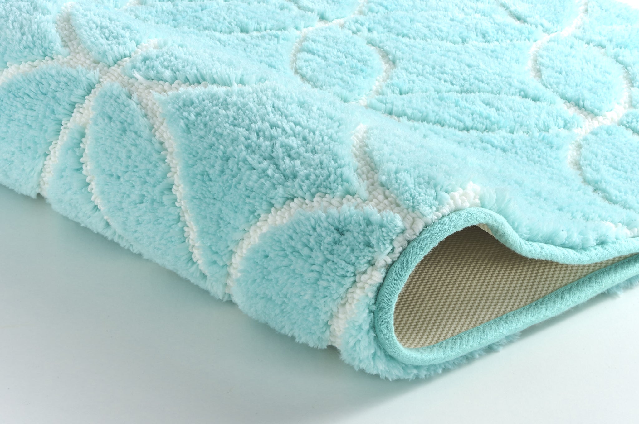 Türkiser, flauschiger Badteppich mit weißem Muster in Nahaufnahme