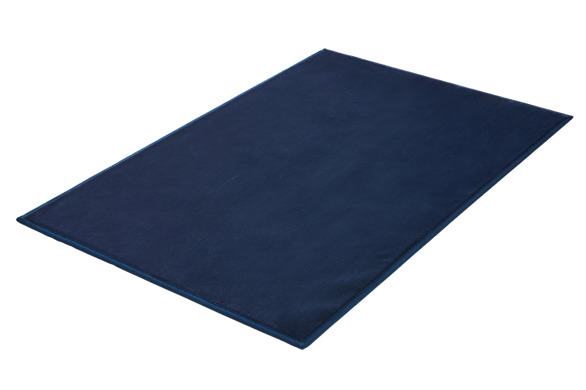 Badteppich VELVET Navy in 70 x 120 cm liegt flach auf hellem Hintergrund.