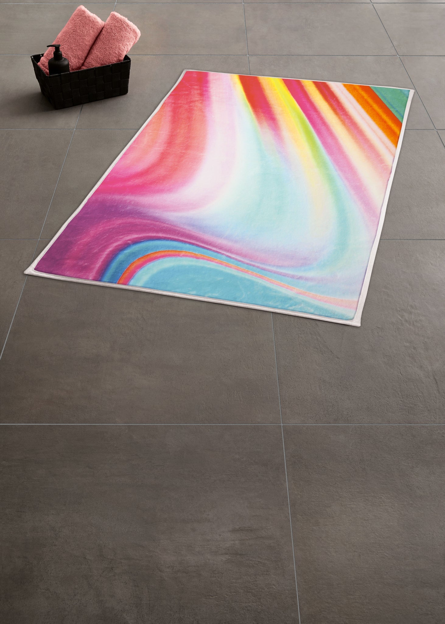 Großes buntes Badetuch mit Farbverlauf auf grauem Fliesenboden
