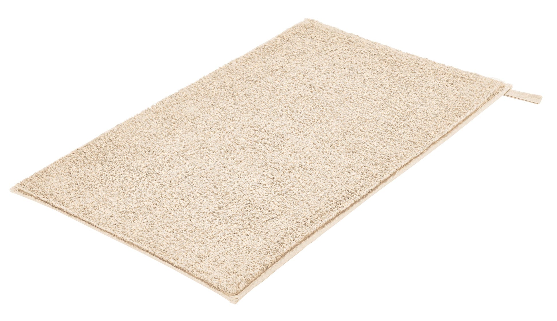 Badteppich VITA Sandbeige 50 x 80 cm liegt rechteckig ausgebreitet auf hellem Untergrund.