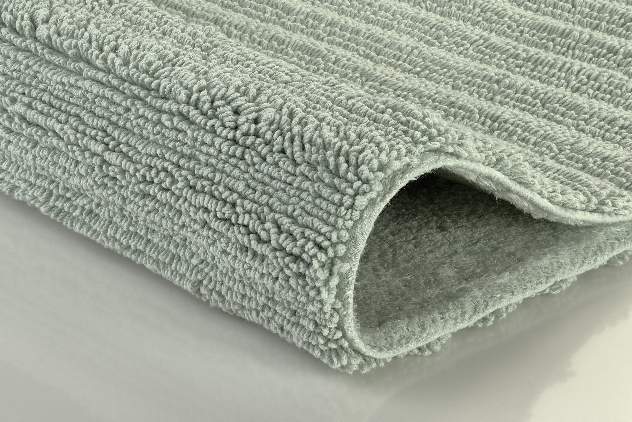 Hellgraue, dicke Badematte mit weicher, gerippter Hochflor-Oberfläche