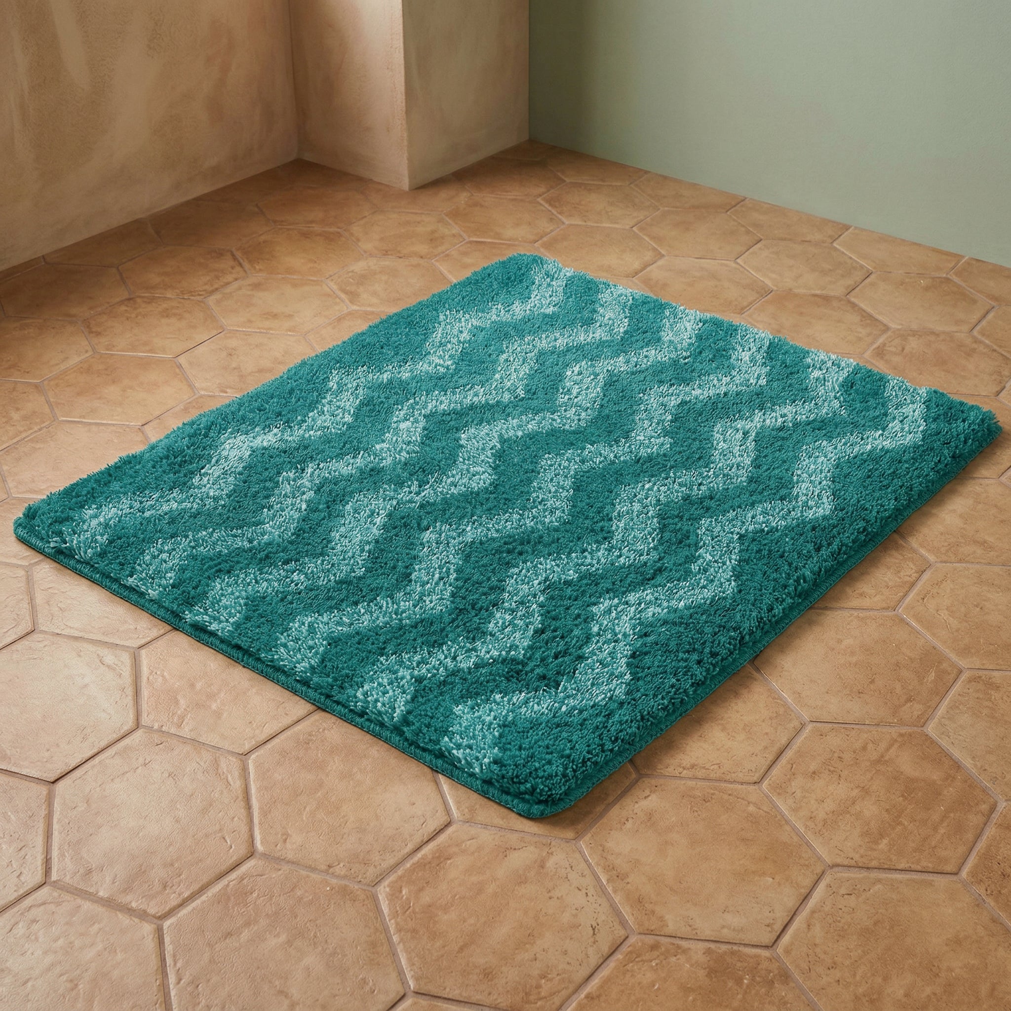 Türkise Badematte mit hellen Zickzack-Streifen auf hellbraunem Fliesenboden