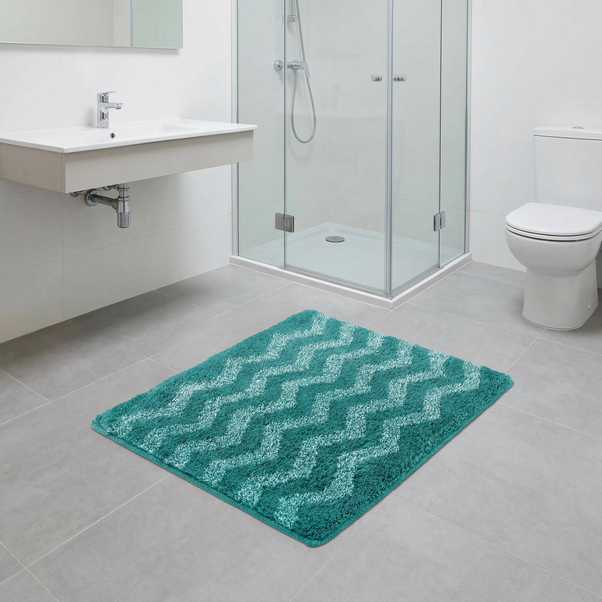 Türkiser Badteppich mit Wellenmuster auf grauen Fliesen im Badboden
