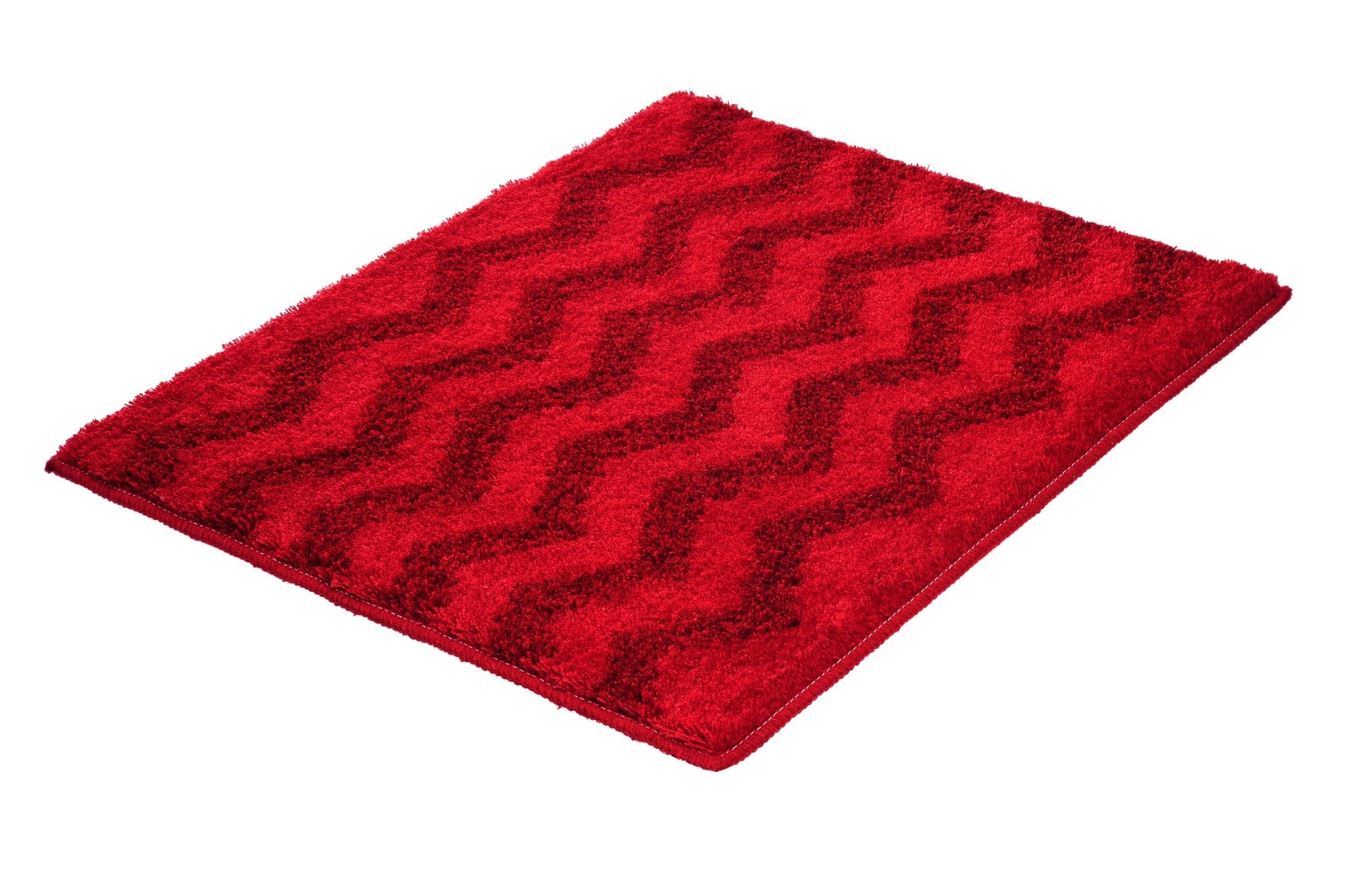 Badteppich ZACK Rubin 55 x 65 cm in Rot mit Zickzack-Struktur liegt auf weißem Hintergrund.