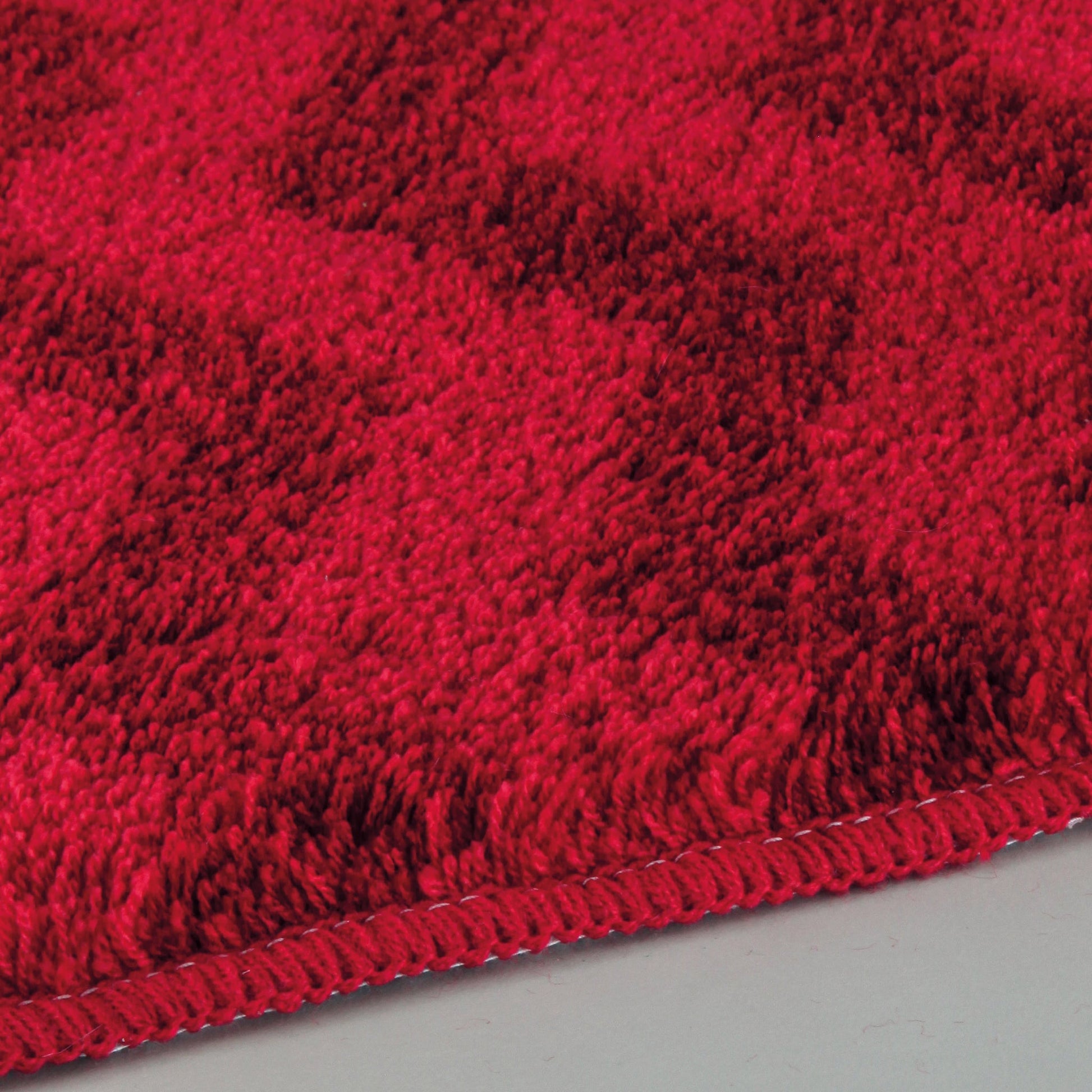 Der Badteppich ZACK Rubin 55 x 65 cm zeigt eine rote Nahaufnahme der dichten Teppichkante.