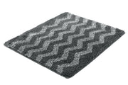 Badteppich ZACK Schiefer 55 x 65 cm mit grauem Zickzackmuster liegt auf dem Boden.