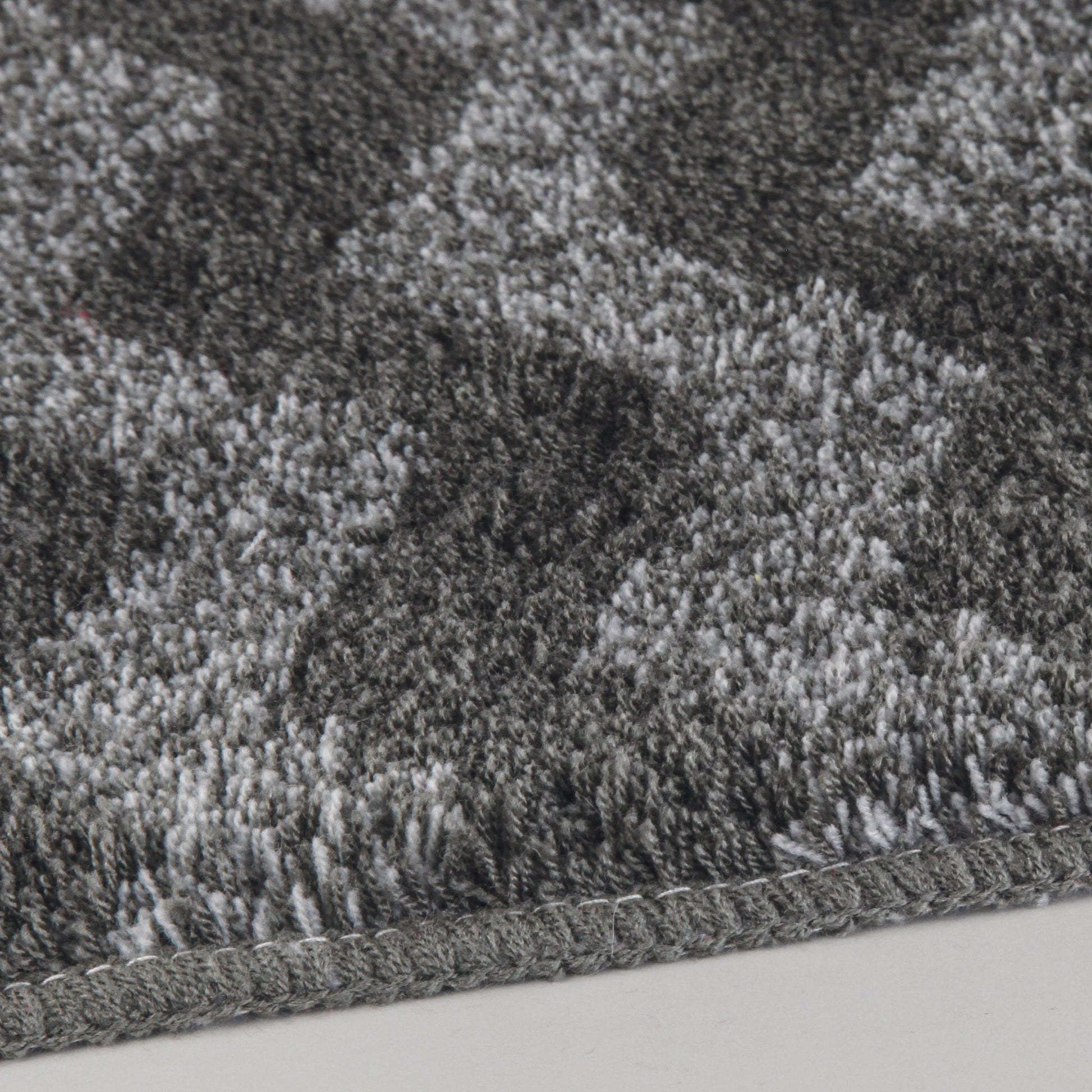 Detailansicht des Badteppichs ZACK Schiefer 60 x 90 cm mit grauem Hochflor-Muster.