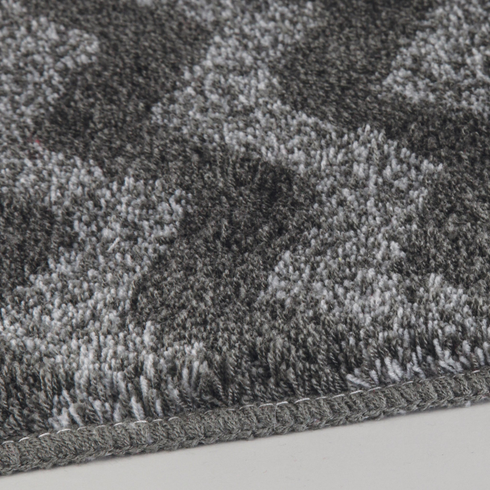 Nahaufnahme Badteppich ZACK Schiefer 70 x 120 cm mit grauem Muster auf hellem Boden.