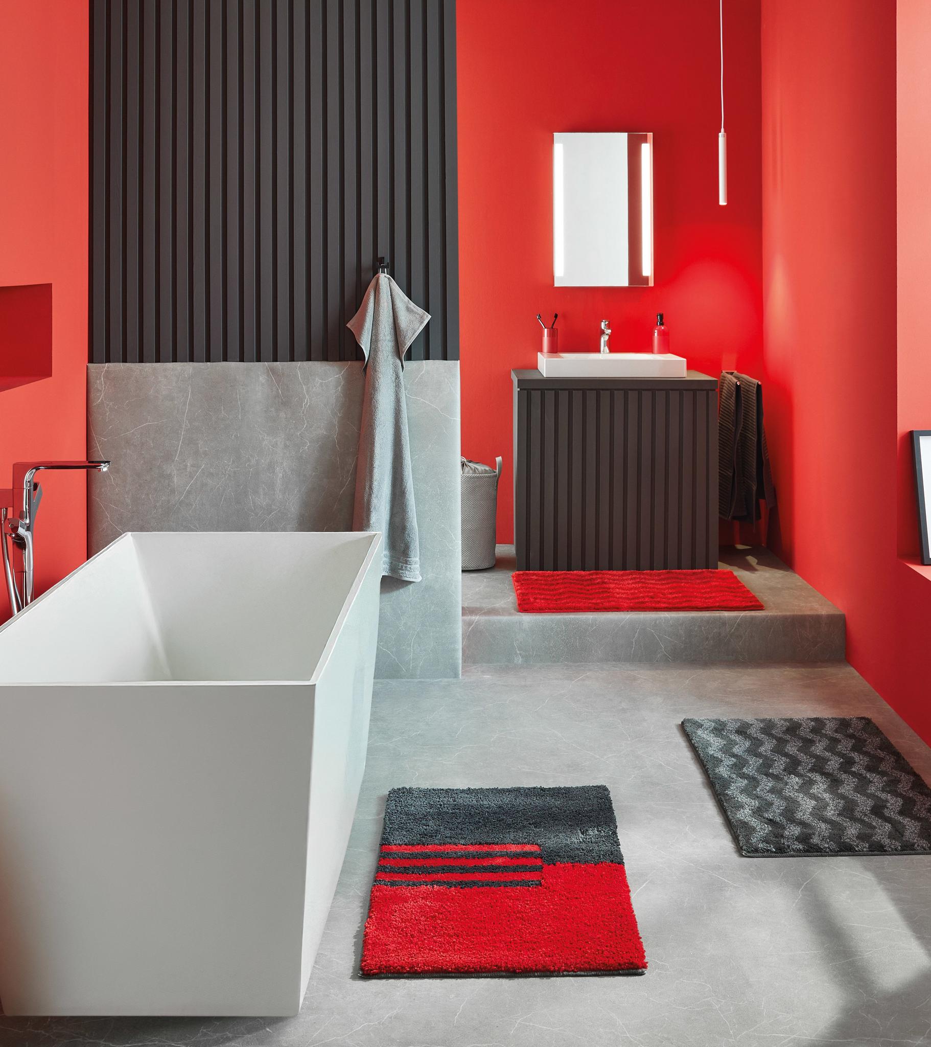 Modernes Bad mit freistehender Wanne und roten Badteppichen in Rot
