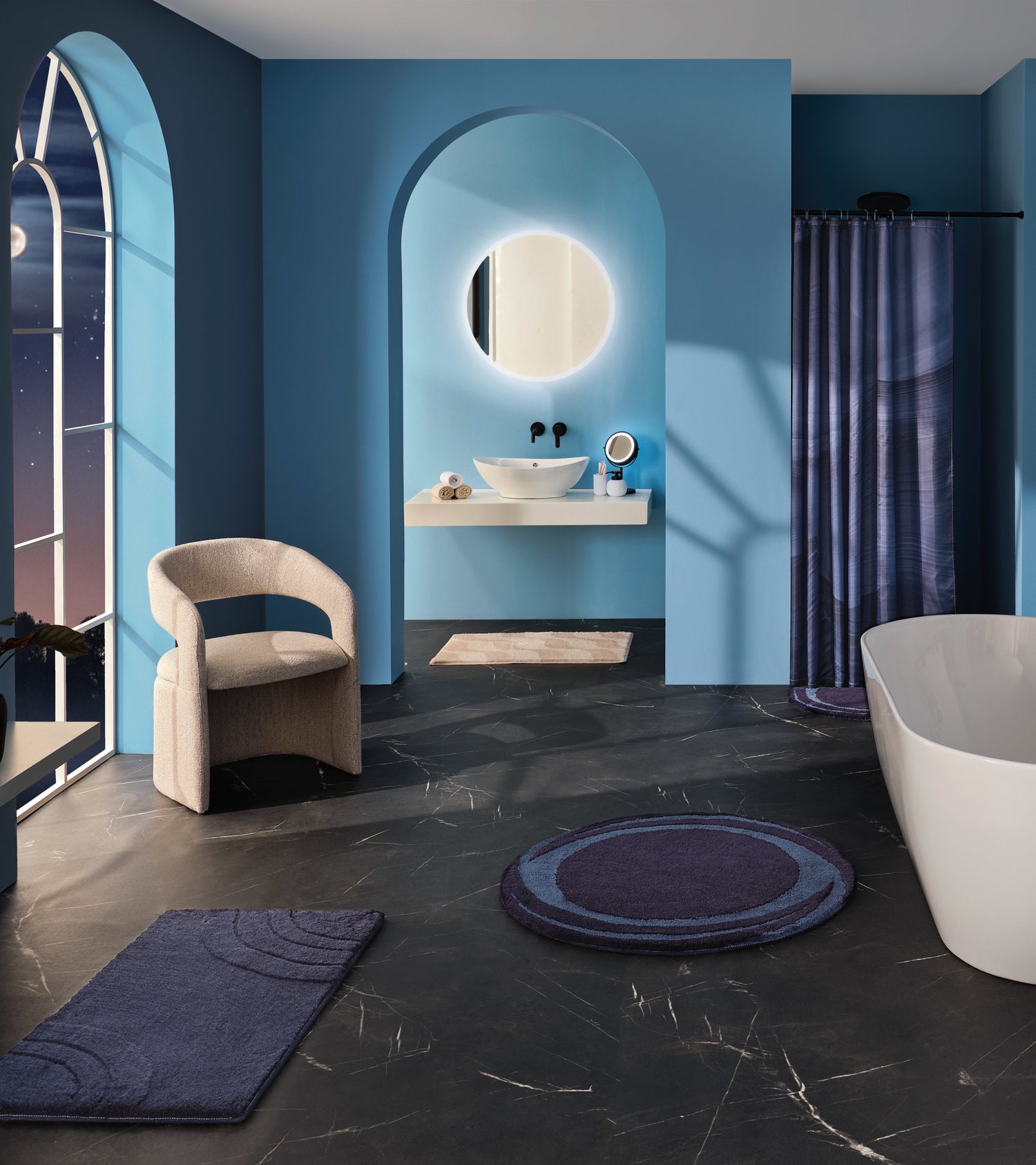 Badezimmer mit blauen Mystic Night Badematten, Duschvorhang und modernem Waschplatz in Nachtkulisse.