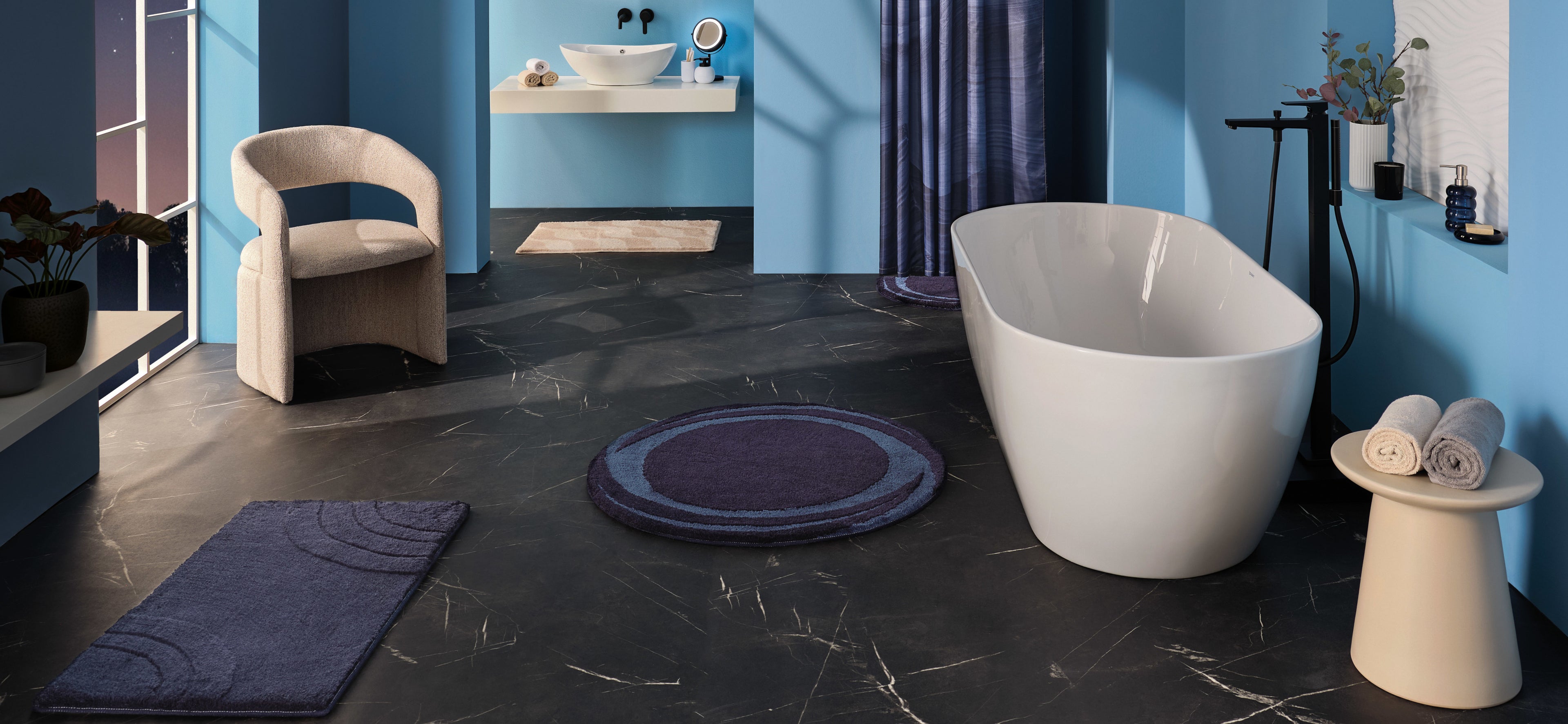 Blaue Badezimmerteppiche Mystic Night in modernem Bad mit freistehender Wanne und dunklem Boden.