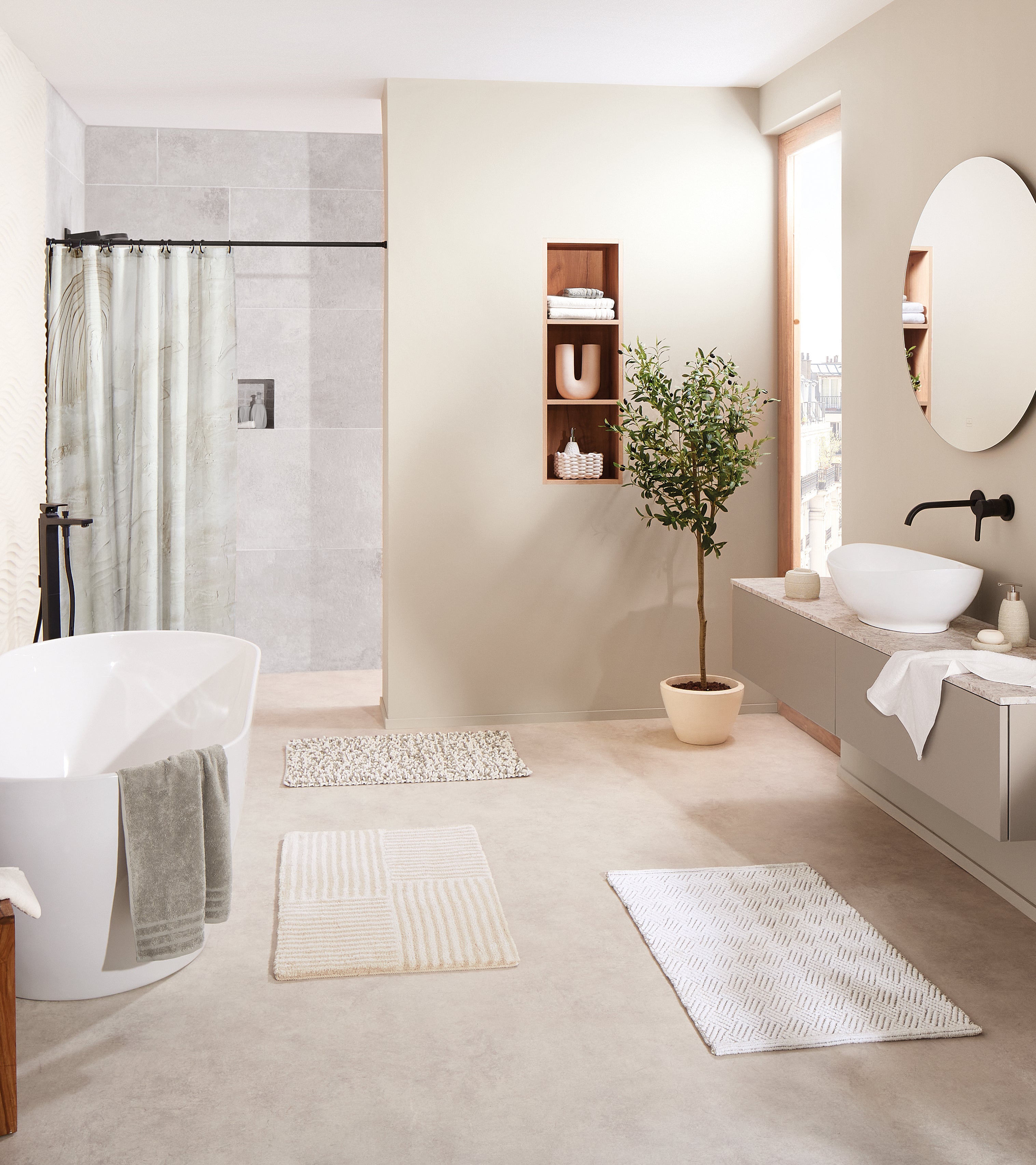 Helles Badezimmer mit Badteppichen von Kleine Wolke vor Dusche, Waschbecken und Badewanne.