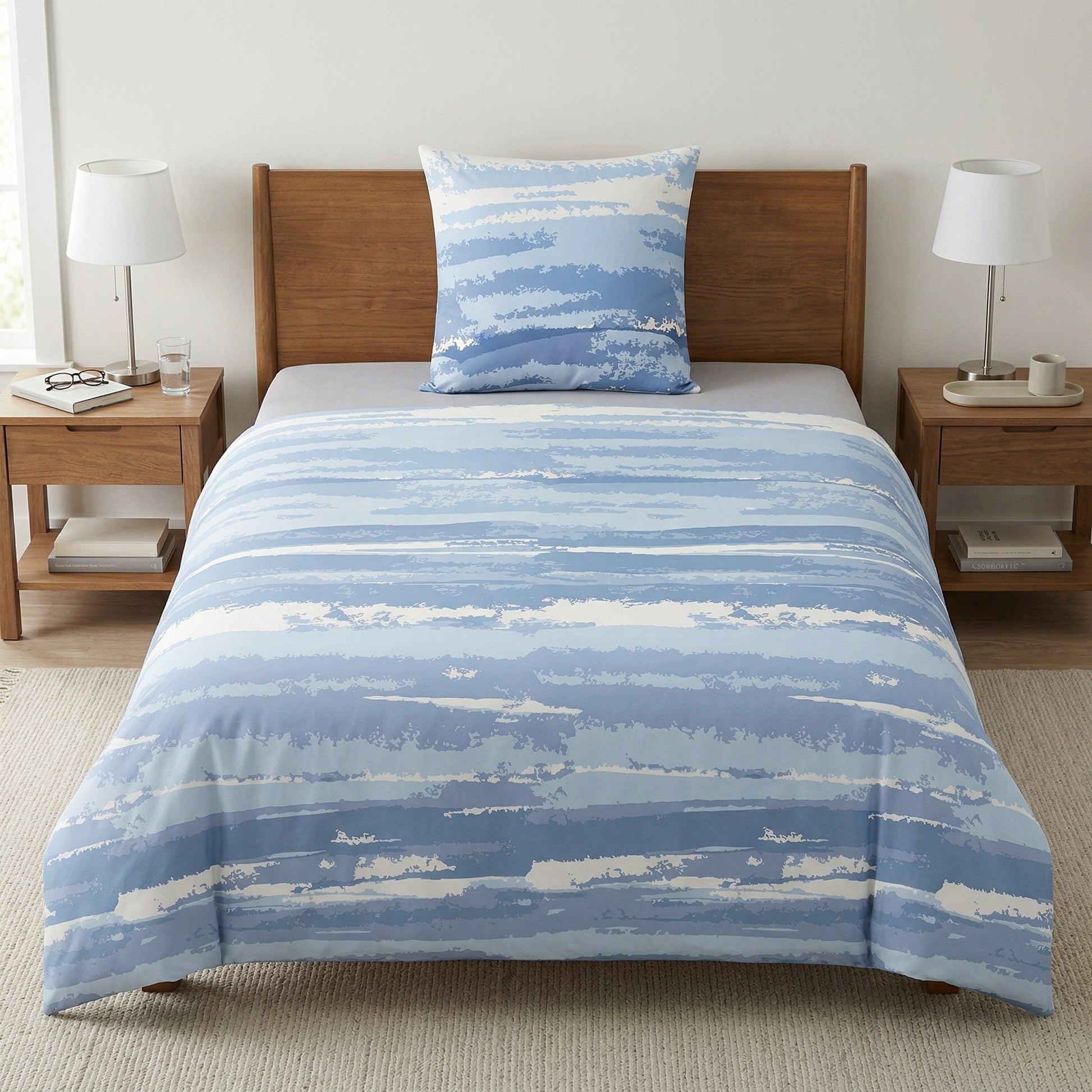 Blaue Bettwäsche mit Streifenmuster auf Bett im hellen Schlafzimmer.