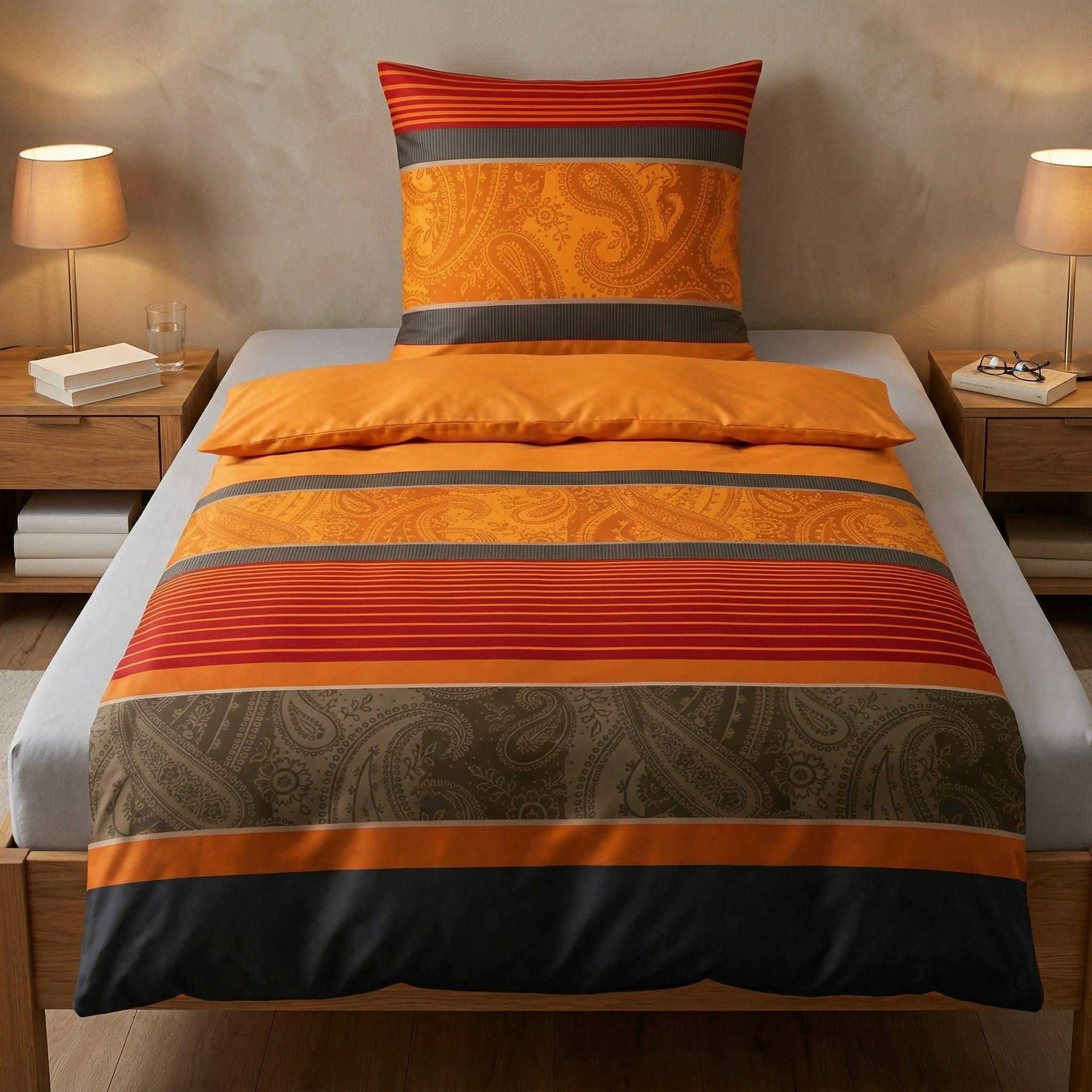 Orange Bettwäsche mit Paisley- und Streifenmuster im Schlafzimmer.