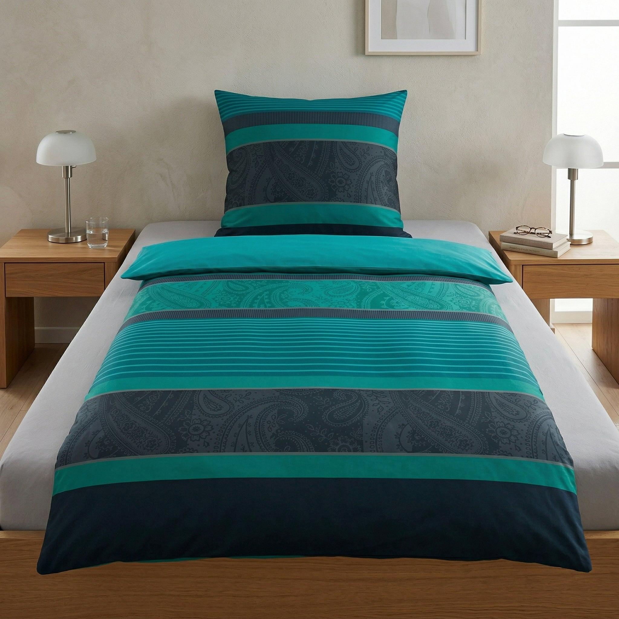 Türkis-graue Bettwäsche mit Paisley-Muster auf modernem Bett.