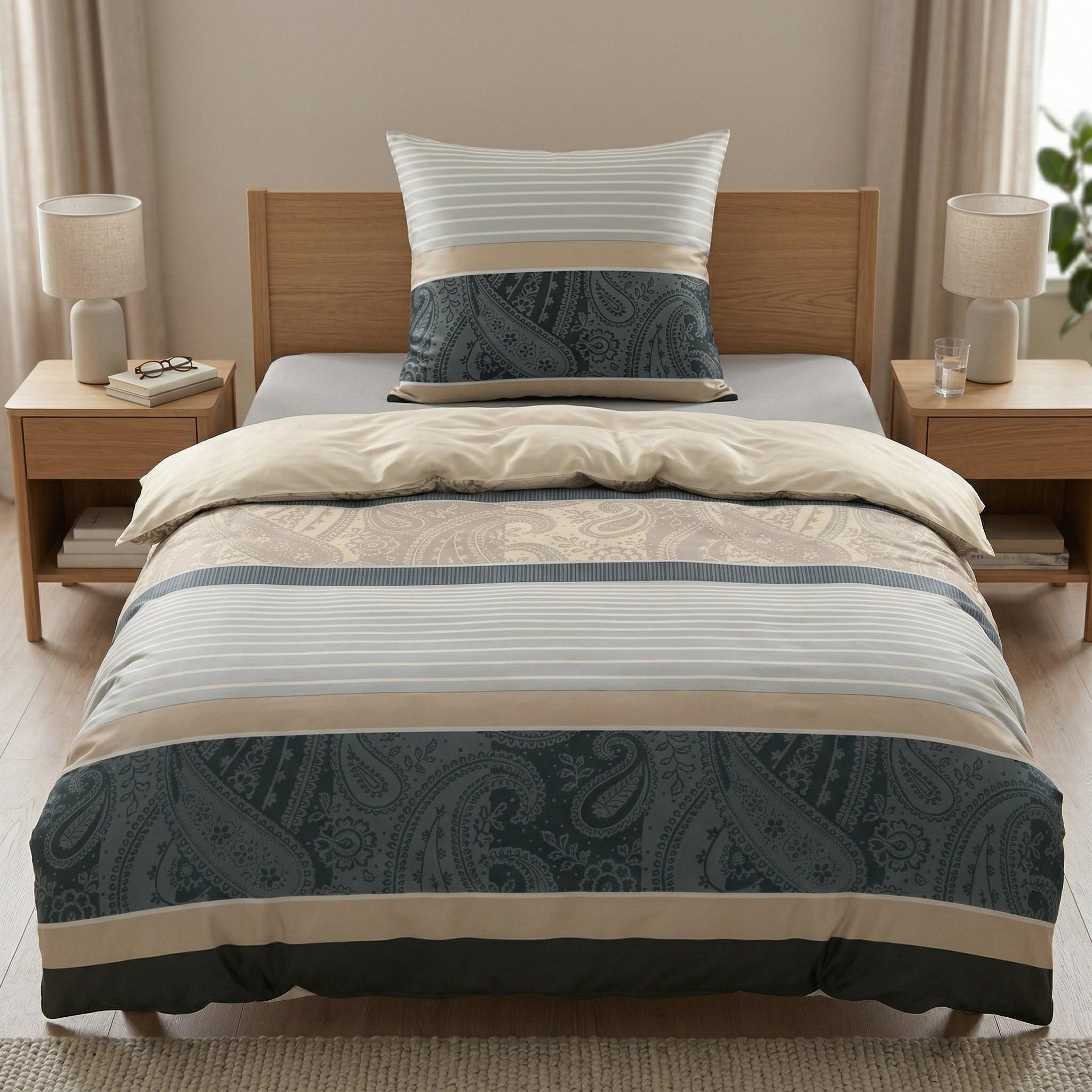 Blau-beige Bettwäsche mit Paisley- und Streifenmuster auf Bett.