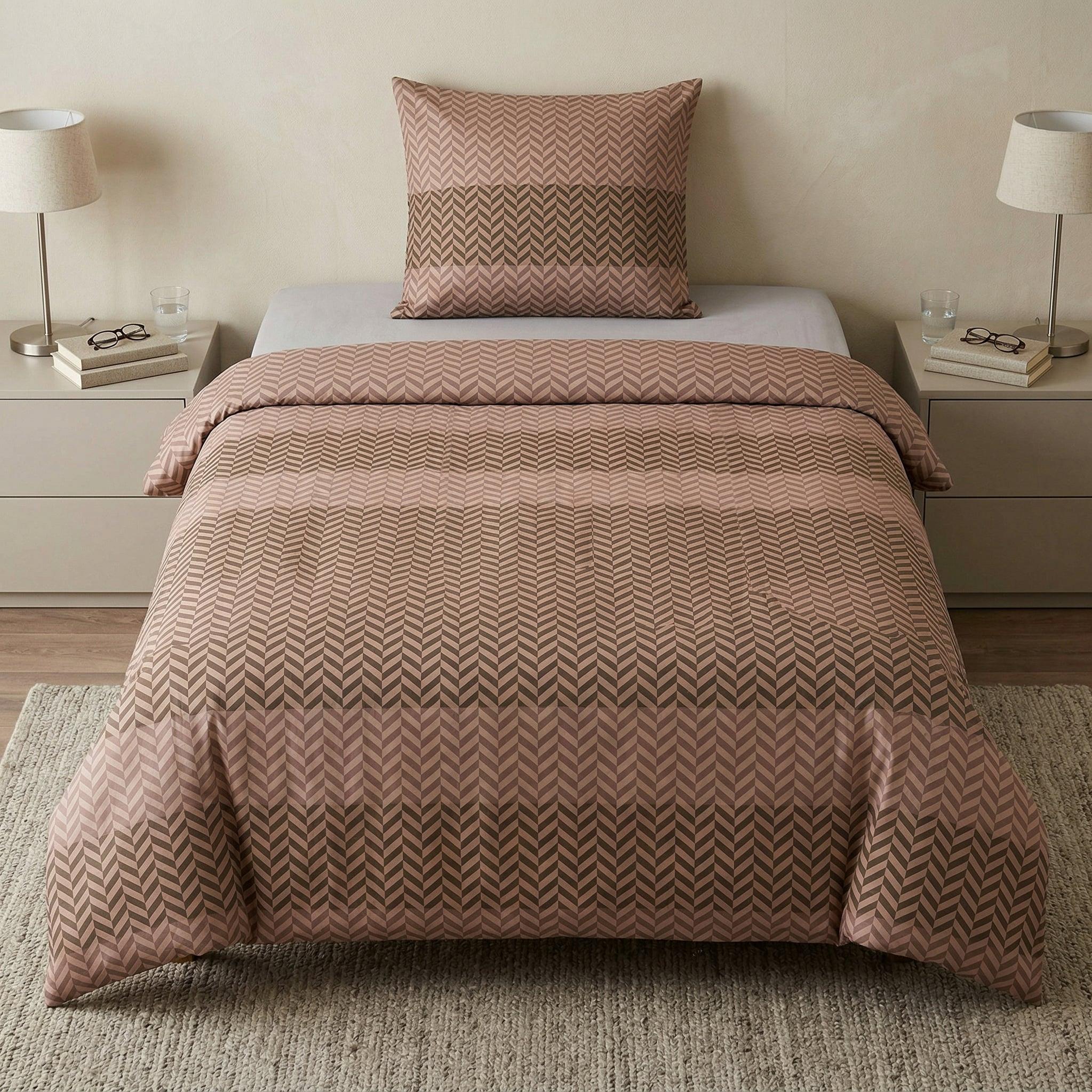 Rosa Bettwäsche mit grafischem Muster auf modern gemachtem Bett.