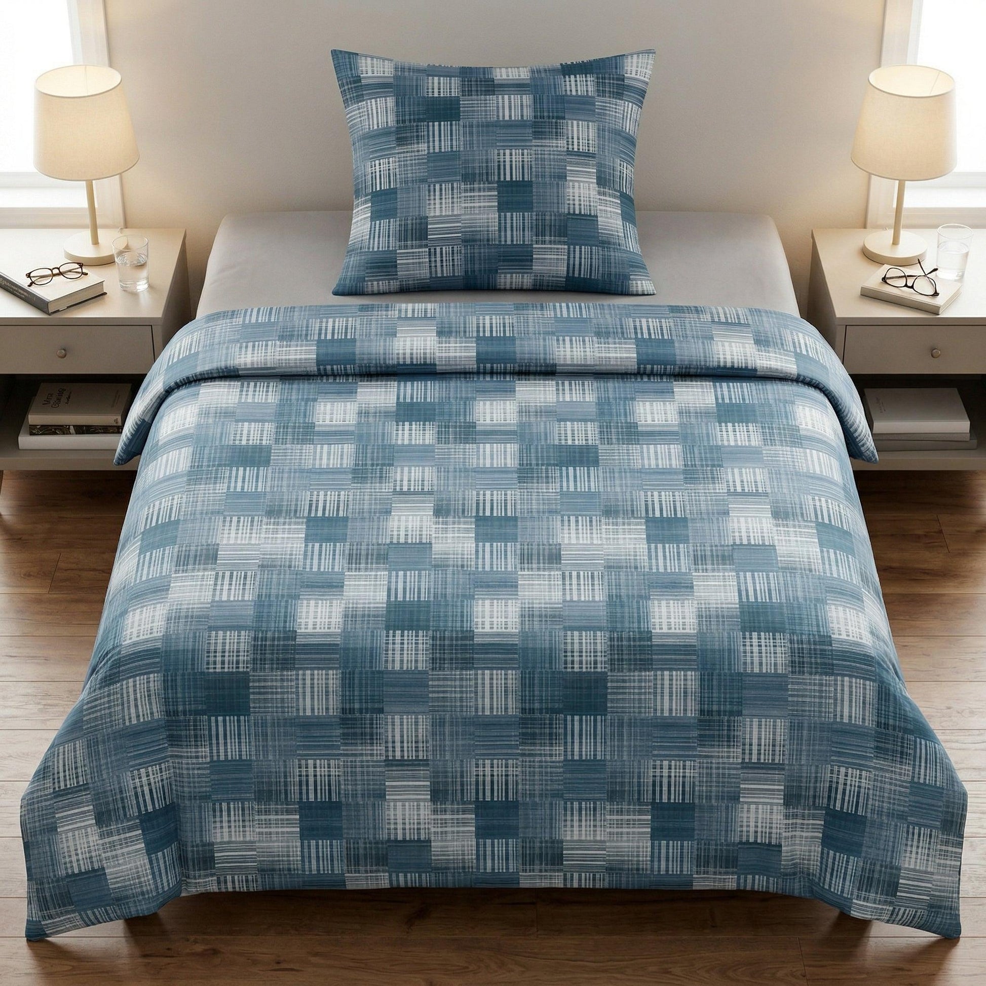 Blaue Bettwäsche mit geometrischem Muster auf modernem Bett.