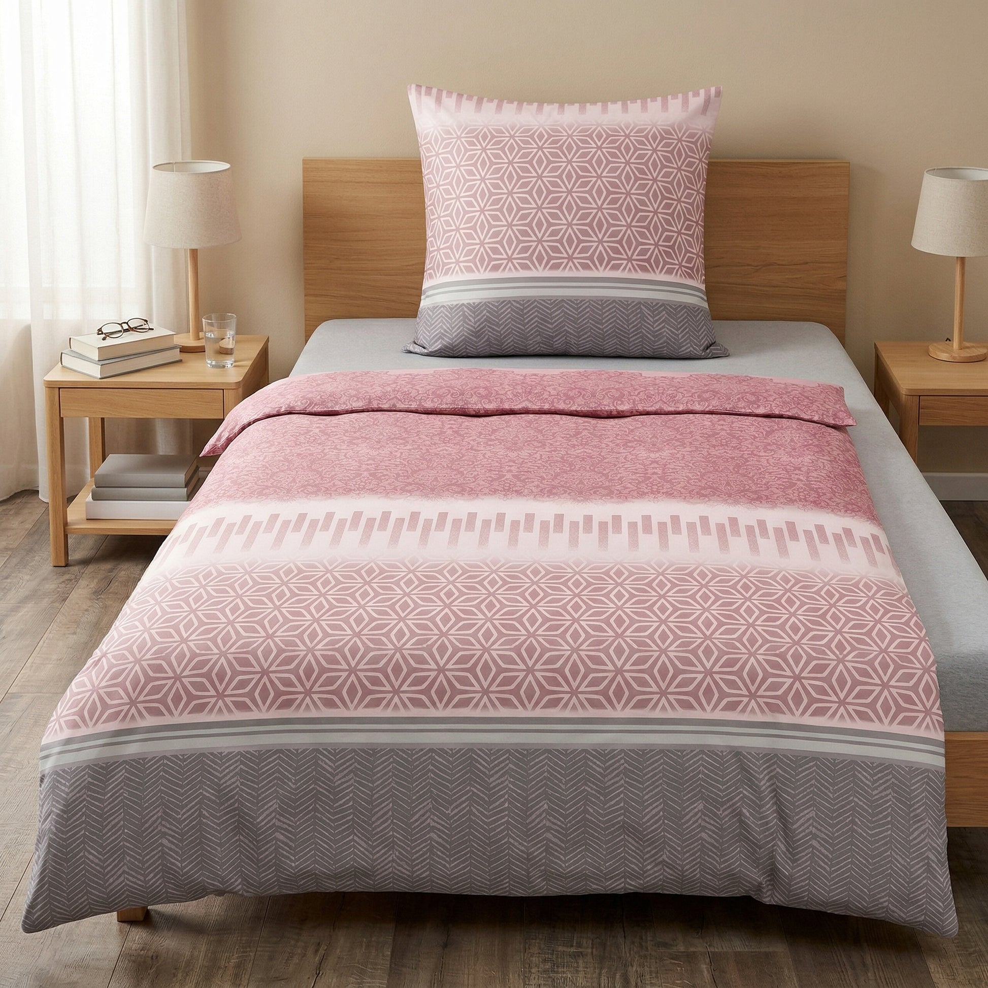 Rosa-graue Bettwäsche mit geometrischem Muster auf Einzelbett.