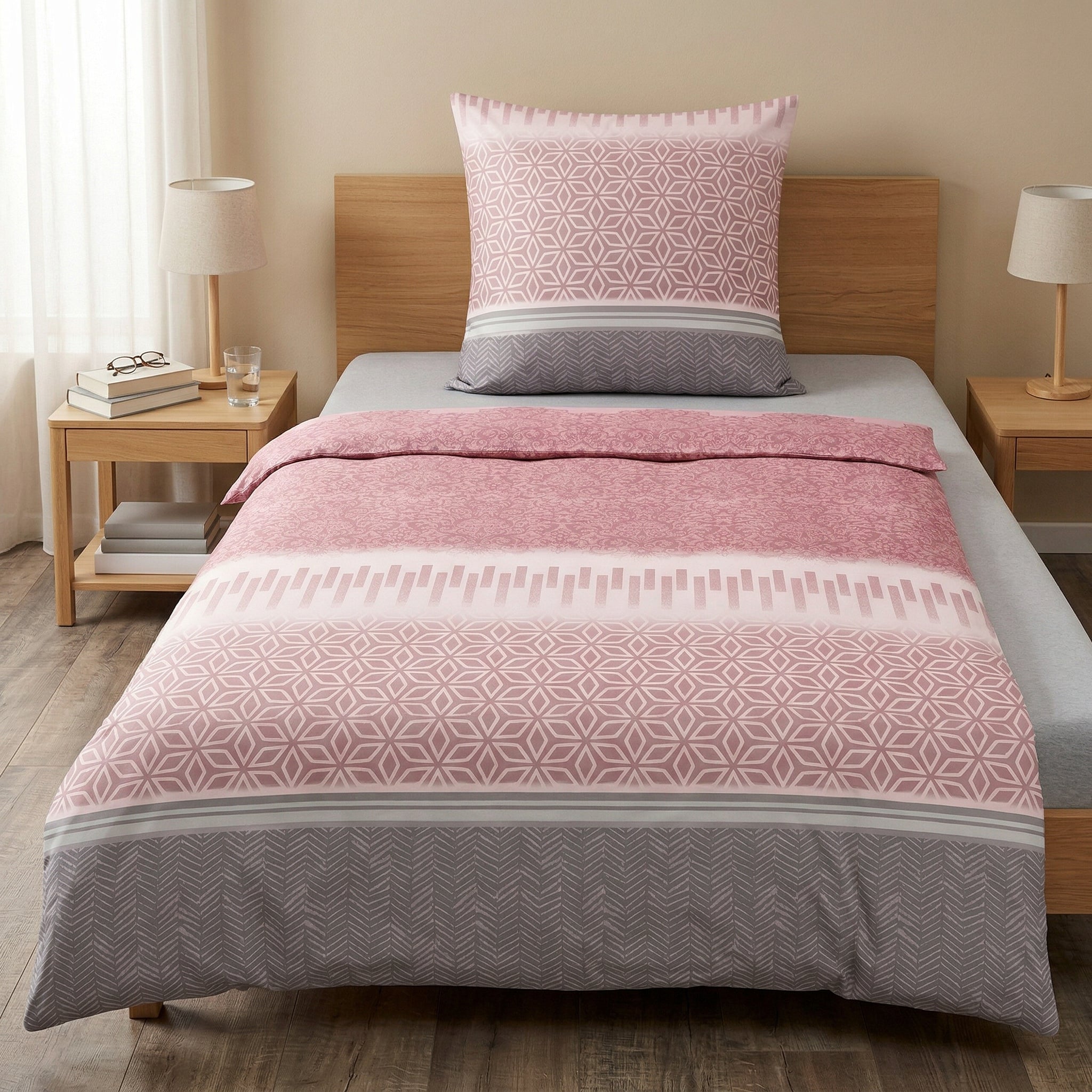 Rosa-graue Bettwäsche mit geometrischem Muster auf Einzelbett.
