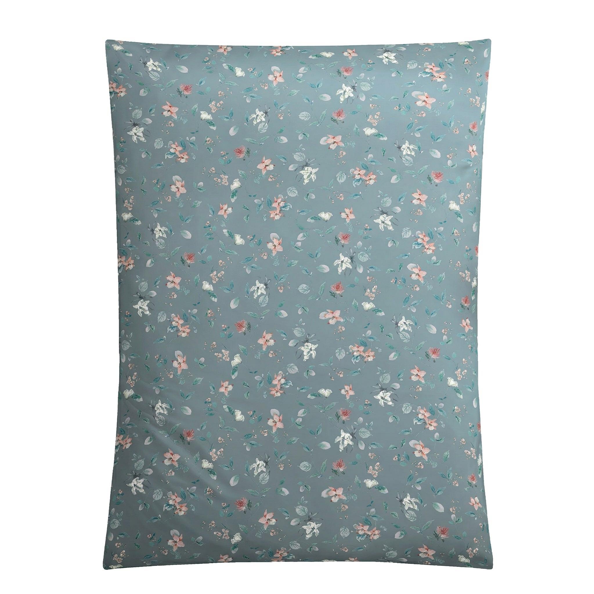 Blaue Bettwäsche mit zartem floralem Streumuster in Rosa und Weiß.