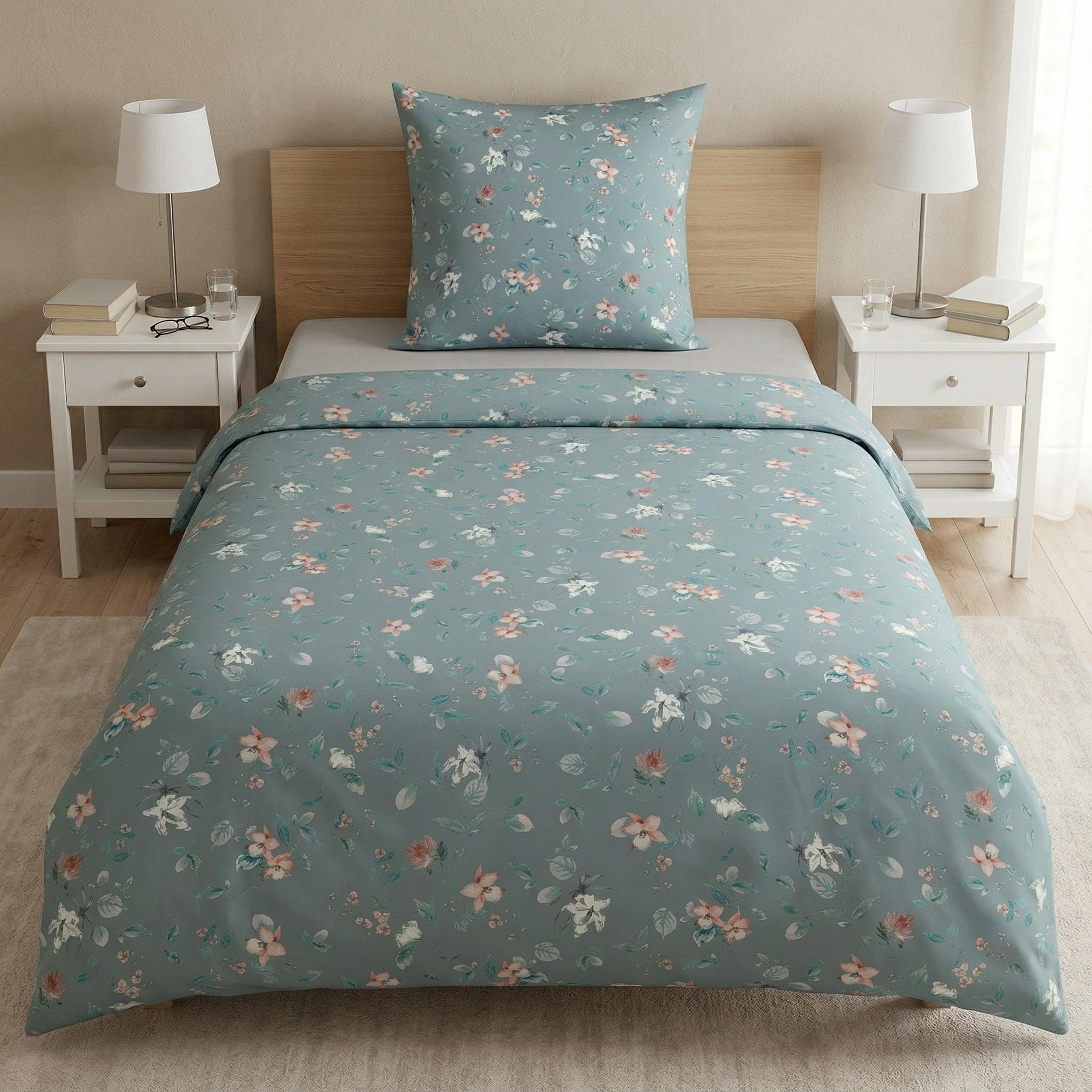 Blaugrüne Bettwäsche mit zartem Blumenmuster auf gemachtem Bett.