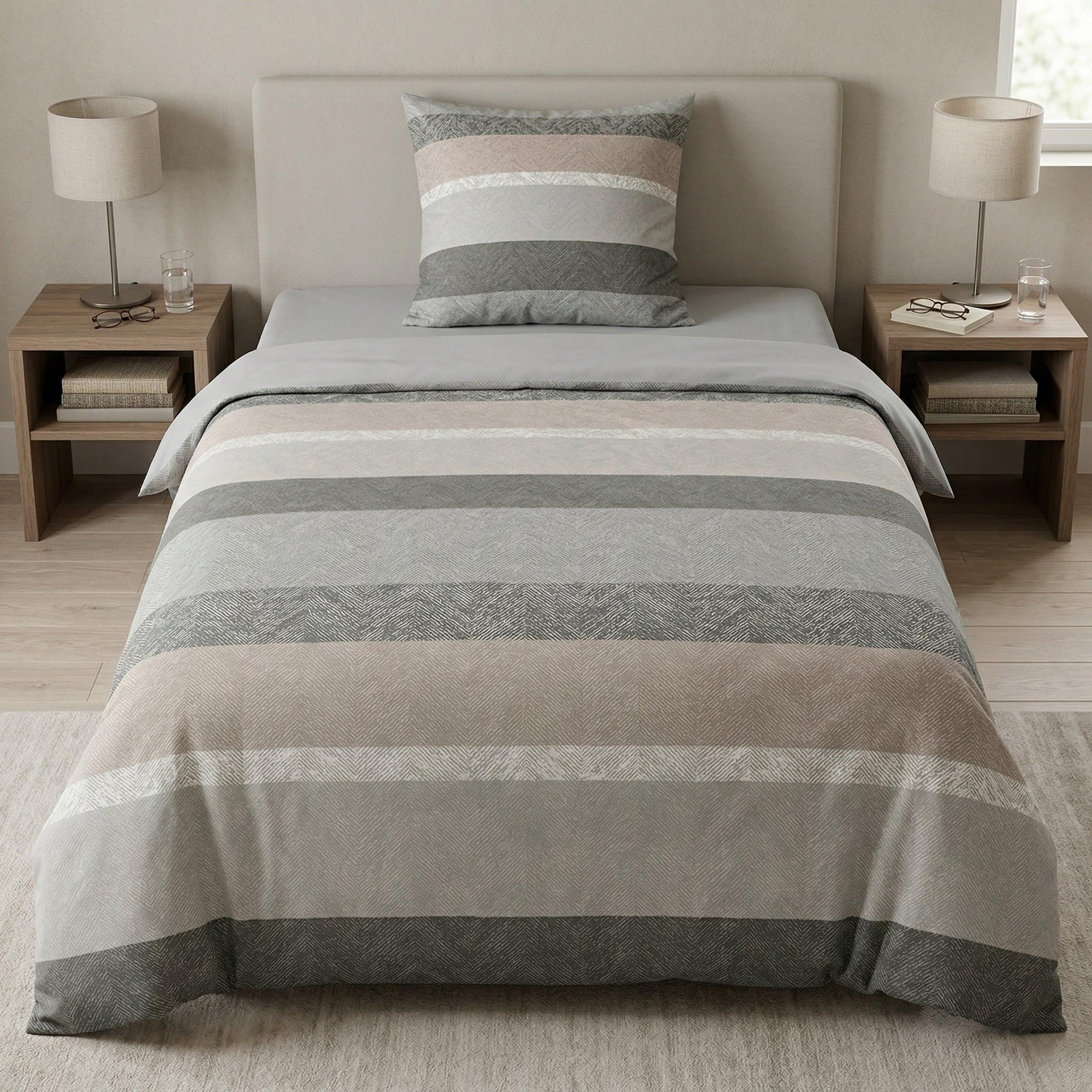 Gestreifte Bettwäsche in Beige und Grau auf modernem Bett.