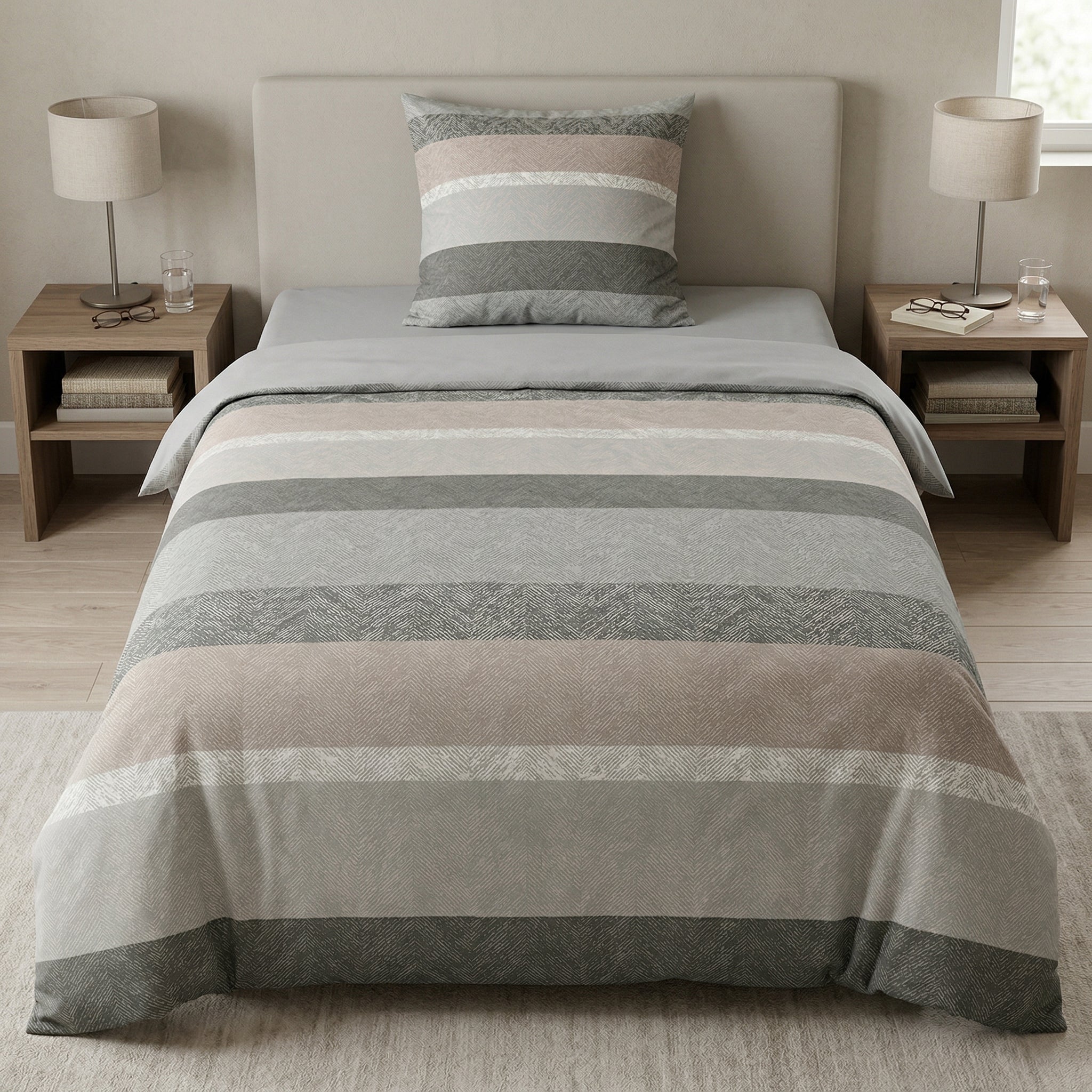 Gestreifte Bettwäsche in Beige und Grau auf modernem Bett.