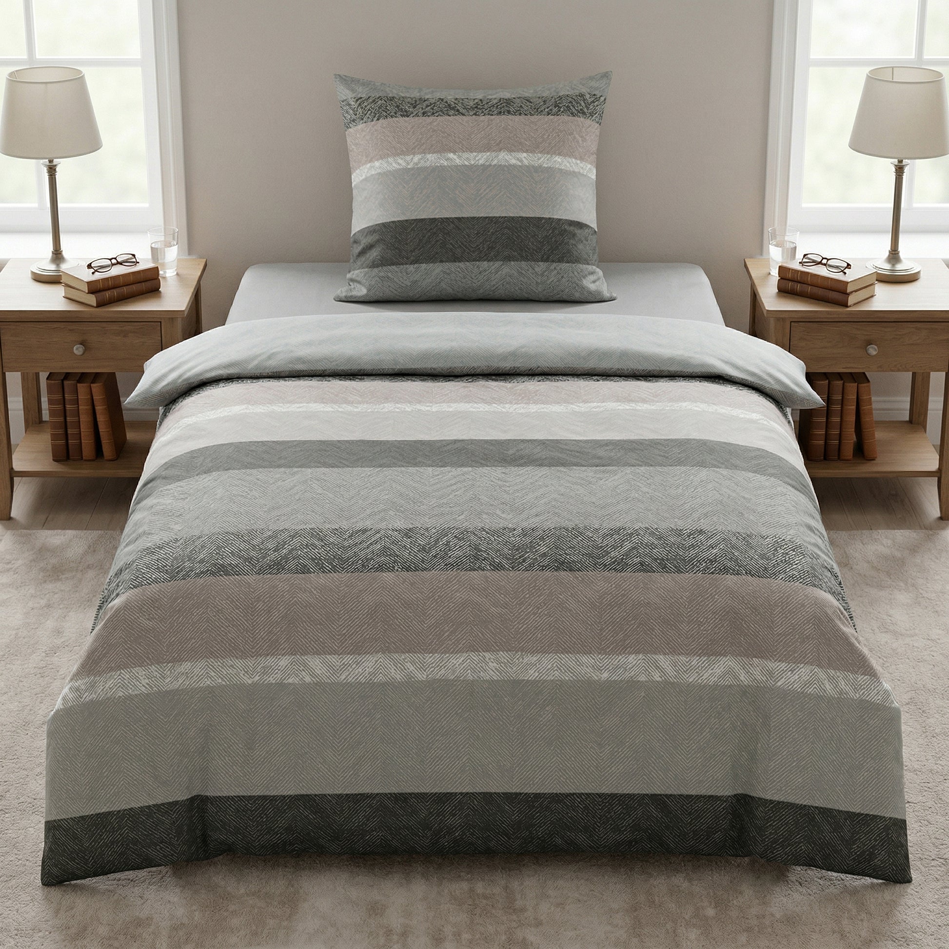 Gestreifte Bettwäsche in Grau und Beige auf modernem Bett.