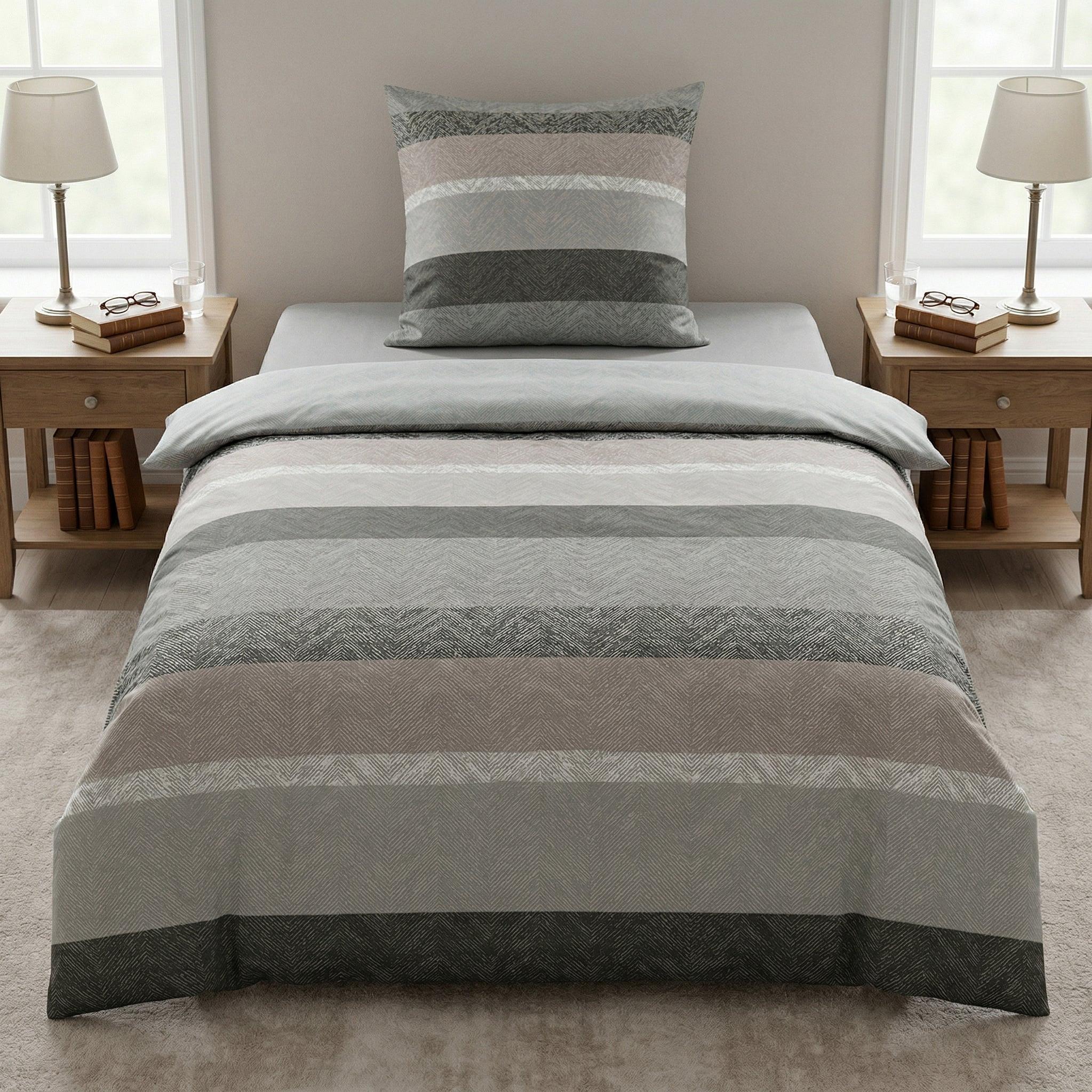 Gestreifte Bettwäsche in Grau und Beige auf modernem Bett.