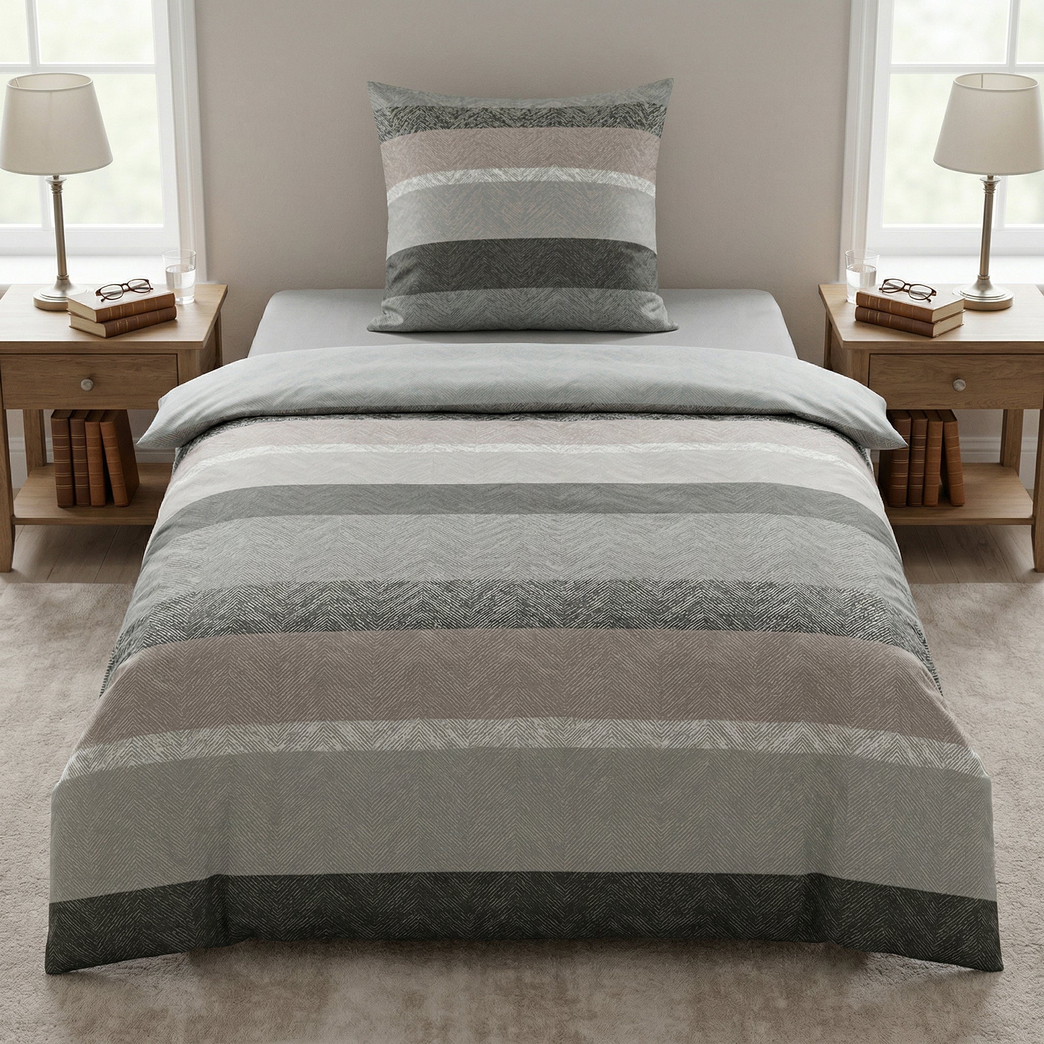 Gestreifte Bettwäsche in Grau und Beige auf modernem Bett.